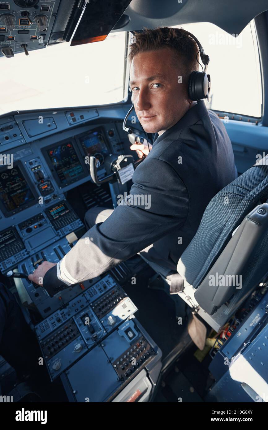 Professioneller Co-Pilot, der vom Cockpit aus einen Blick in die Kamera werfen kann Stockfoto