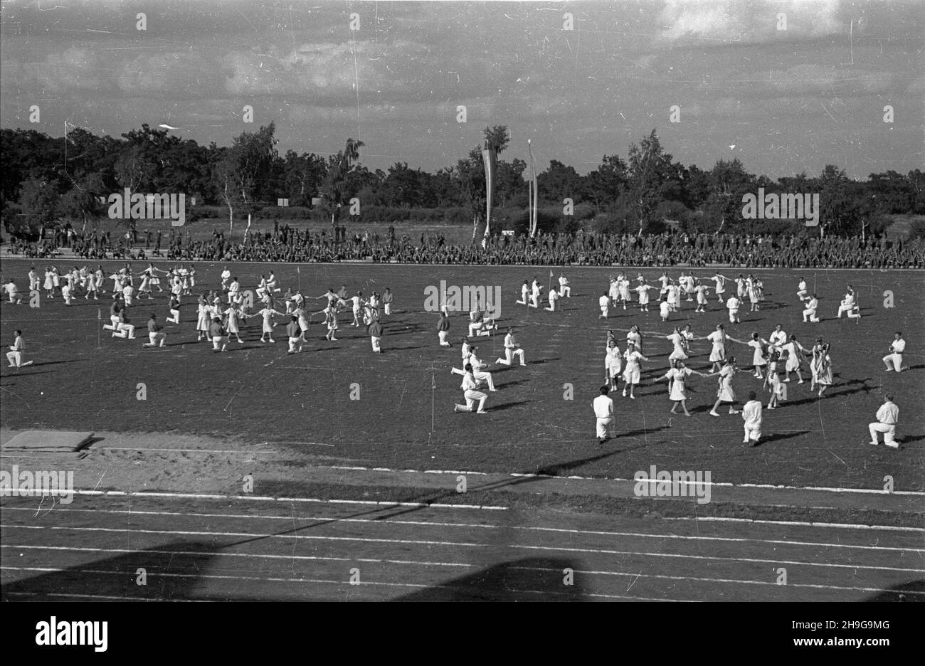 Warszawa, 1948-06-12. Uroczyste zakoñczenie roku akademickiego na Akademii Wychowania Fizycznego im. Józefa Pi³sudskiego na stadionie uczelni na Bielanach. NZ. Pokaz tañców ludowych w wykonaniu studentów, na trybunach m.in. Junacy z Powszechnej Organizacji S³u¿BA Polsce. As PAP Warschau, 12. Juni 1948. Die Abschlussfeier für das akademische Jahr an der Jozef Pilsudski Physical Education Academy fand im Stadion der Akademie im Stadtteil Bielany statt. Im Bild: Volkstänze von Studenten, an den Ständen Mitglieder der Massenorganisation Service nach Polen. Als PAP Stockfoto