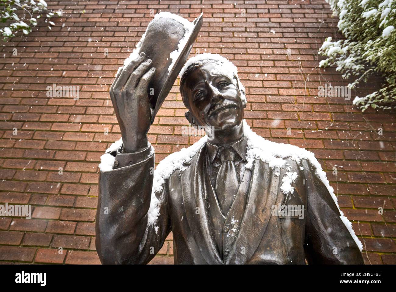 Winterschnee im Dorf Denton in Tameside, Jubilee Square, Albert Street, Bronzestatue „Tipping the Denton Linney“ Stockfoto