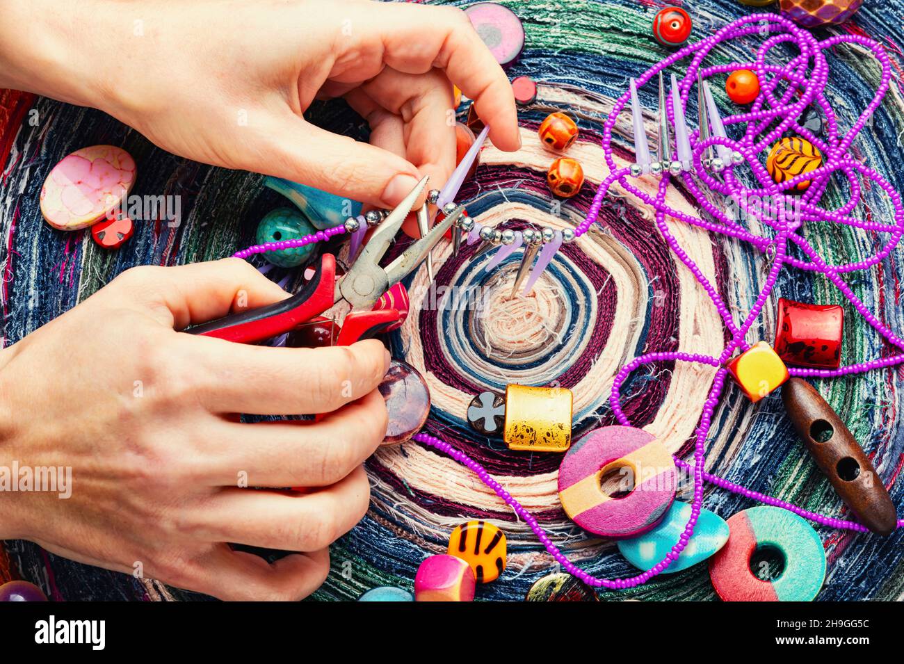 Perlen verschiedener Art für Nadelarbeit. Perlen auf einem bunten Hintergrund. Stockfoto