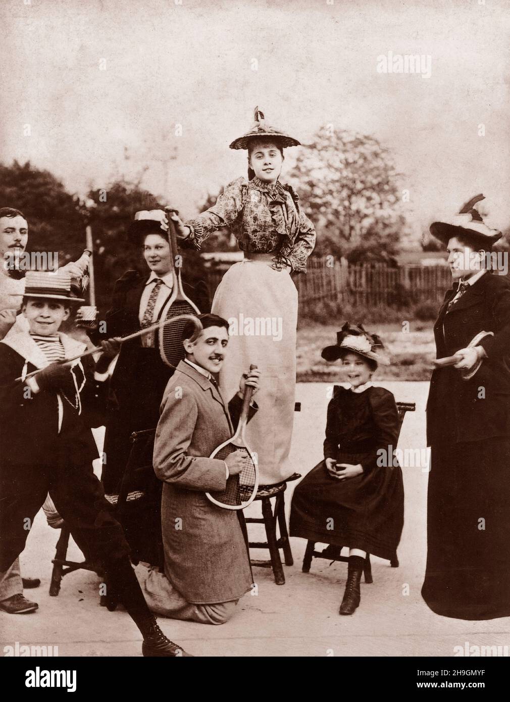 Marcel Proust (1871-1922) mit einem Tennisschläger vor Jeanne Ponquet, der auf einem Stuhl auf dem Pariser Tennisboulevard Bineau 1892 steht Stockfoto
