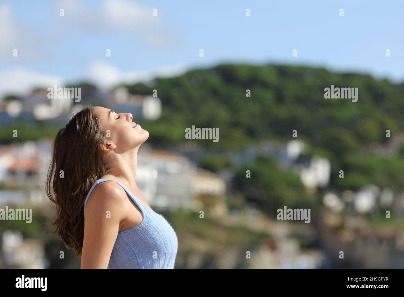 Profil einer Frau, die frische Luft atmet und in einer Bergstadt steht Stockfoto