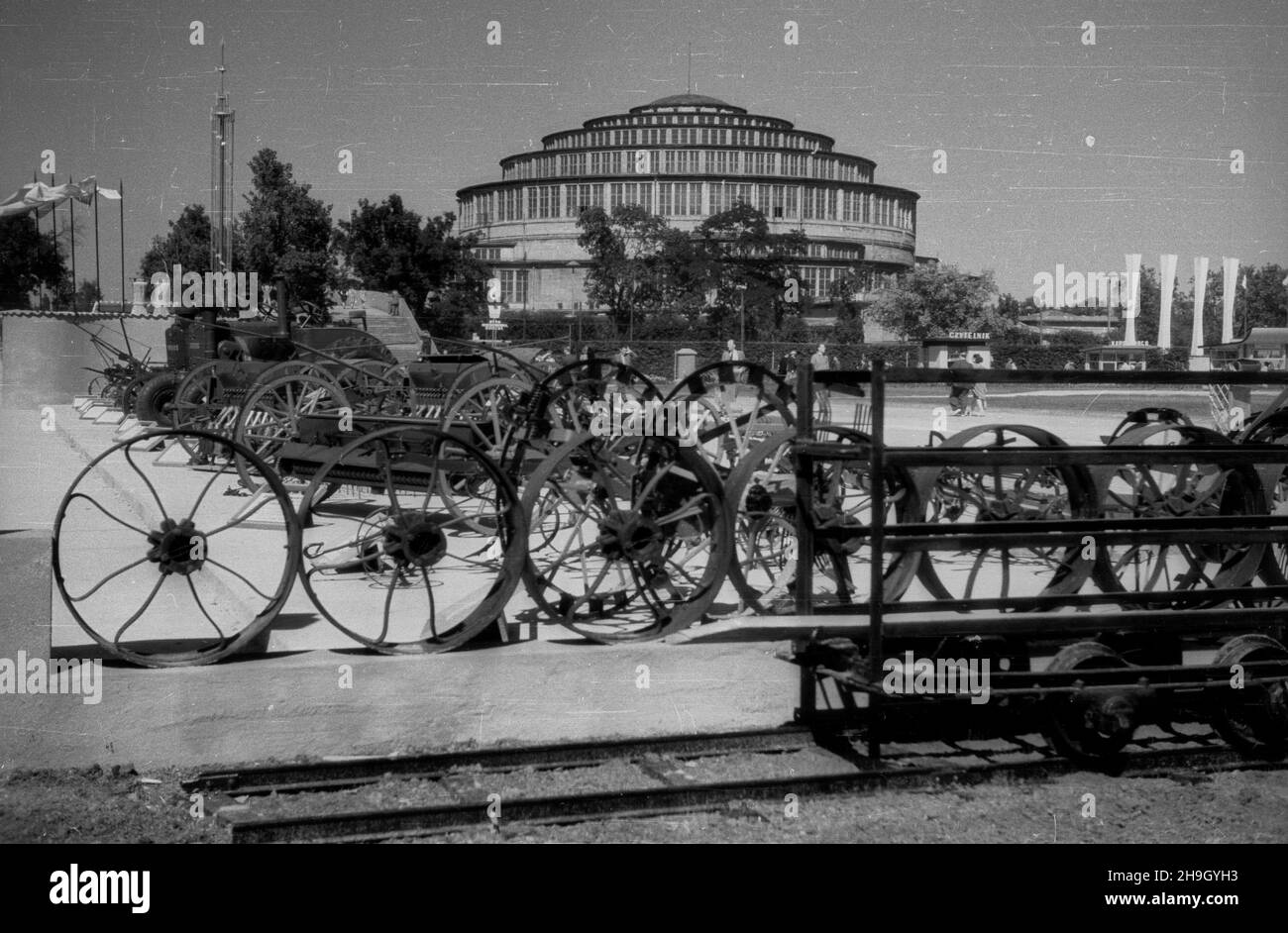 Wroc³aw, 1948-07. W dniach od 21 lipca do 31 paŸdziernika odbywa³a siê Wystawa Ziem Odzyskanych, która mia³a udowodniæ polskoœæ Œl¹ska. W kilkudziesiêciu pawilonach prezentowano dokonania Polski Ludowej. NZ. Wystawa maszyn rolniczych na dziedziñcu przed pawilonem przemys³u (tzw. Hal¹ Berga); w tle Hala Ludowa (Hala Stulecia). pw PAP Dok³adny dzieñ wydarzenia nieustalony. Breslau, Juli 1948. Vom 21. Juli bis 31. Oktober fand die Ausstellung der wiedergewonnenen Gebiete statt, die die Schlesische Polisiertheit beweisen sollte. In mehreren doz. wurden die Errungenschaften der Polnischen Volksrepublik vorgestellt Stockfoto