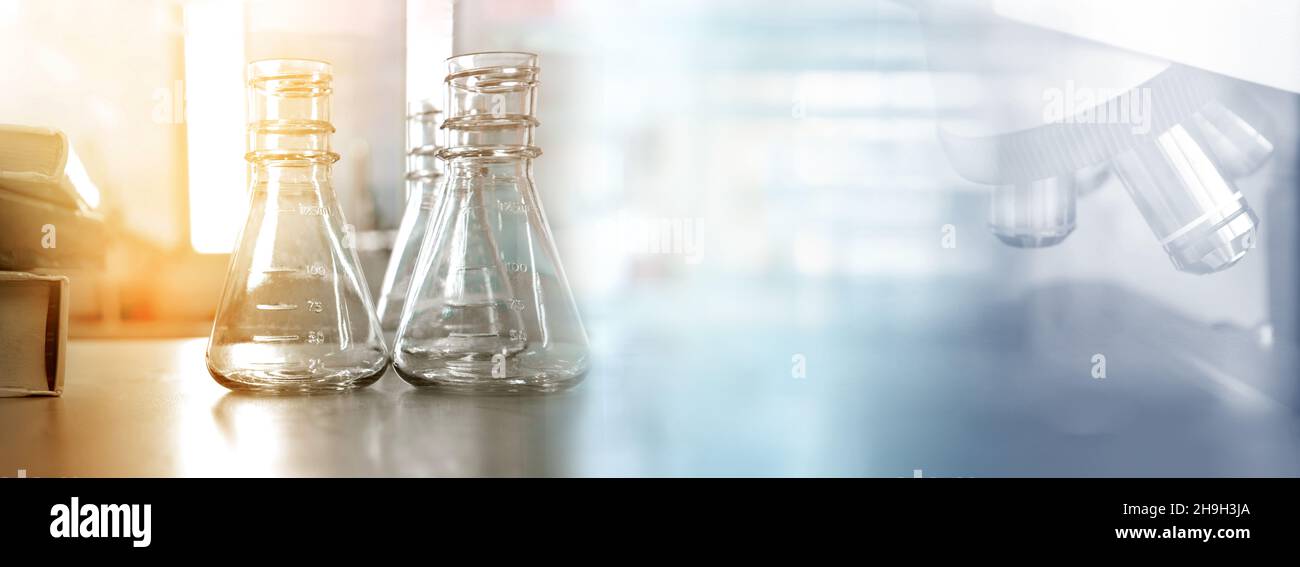 Klare Flasche und Textbuch mit Mikroskop in Gesundheit Wissenschaft Labor Bildung Banner Hintergrund Stockfoto