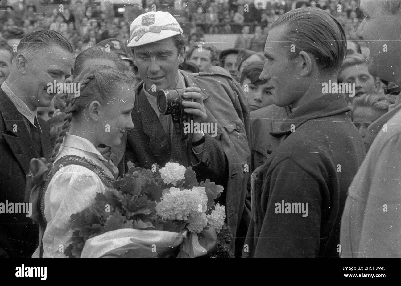 Warszawa, 1948-07-04. OD 22 czerwca do 4 lipca odbywa³ siê VII Kolarski Wyœcig Dooko³a Polski (Tour de Pologne). Ostatni, jedenasty etap z £odzi do Warszawy (134 km) koñczy³ siê na stadionie Wojskowego Klubu Sportowego Legia. NZ. uroczystoœæ wrêczenia wieñca laurowego zwyciêzcy wyœcigu Wac³awowi Wójcikowi (Polska I) (P). Z mikrofonem polski sprawozdawca sportowy Bohdan Tomaszewski. pw PAP/Wojciech Kondracki Warschau, 4. Juli 1948. Das Radrennen der Tour de Pologne 7th fand vom 22. Juni bis 4. Juli statt. Die letzte, elfte Etappe von Lodz nach Warschau (134 km) endete im Stadion des Militärs sp Stockfoto