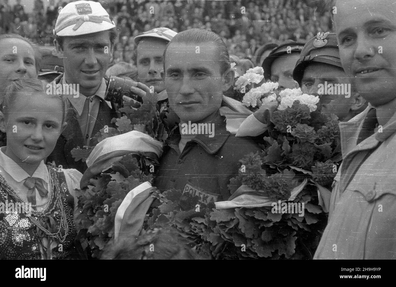 Warszawa, 1948-07-04. OD 22 czerwca do 4 lipca odbywa³ siê VII Kolarski Wyœcig Dooko³a Polski (Tour de Pologne). Ostatni, jedenasty etap z £odzi do Warszawy (134 km) koñczy³ siê na stadionie Wojskowego Klubu Sportowego Legia. NZ. uroczystoœæ wrêczenia wieñca laurowego zwyciêzcy wyœcigu Wac³awowi Wójcikowi (Polska I) (C). Z mikrofonem polski sprawozdawca sportowy Bohdan Tomaszewski. pw PAP/Wojciech Kondracki Warschau, 4. Juli 1948. Das Radrennen der Tour de Pologne 7th fand vom 22. Juni bis 4. Juli statt. Die letzte, elfte Etappe von Lodz nach Warschau (134 km) endete im Stadion des Militärs sp Stockfoto