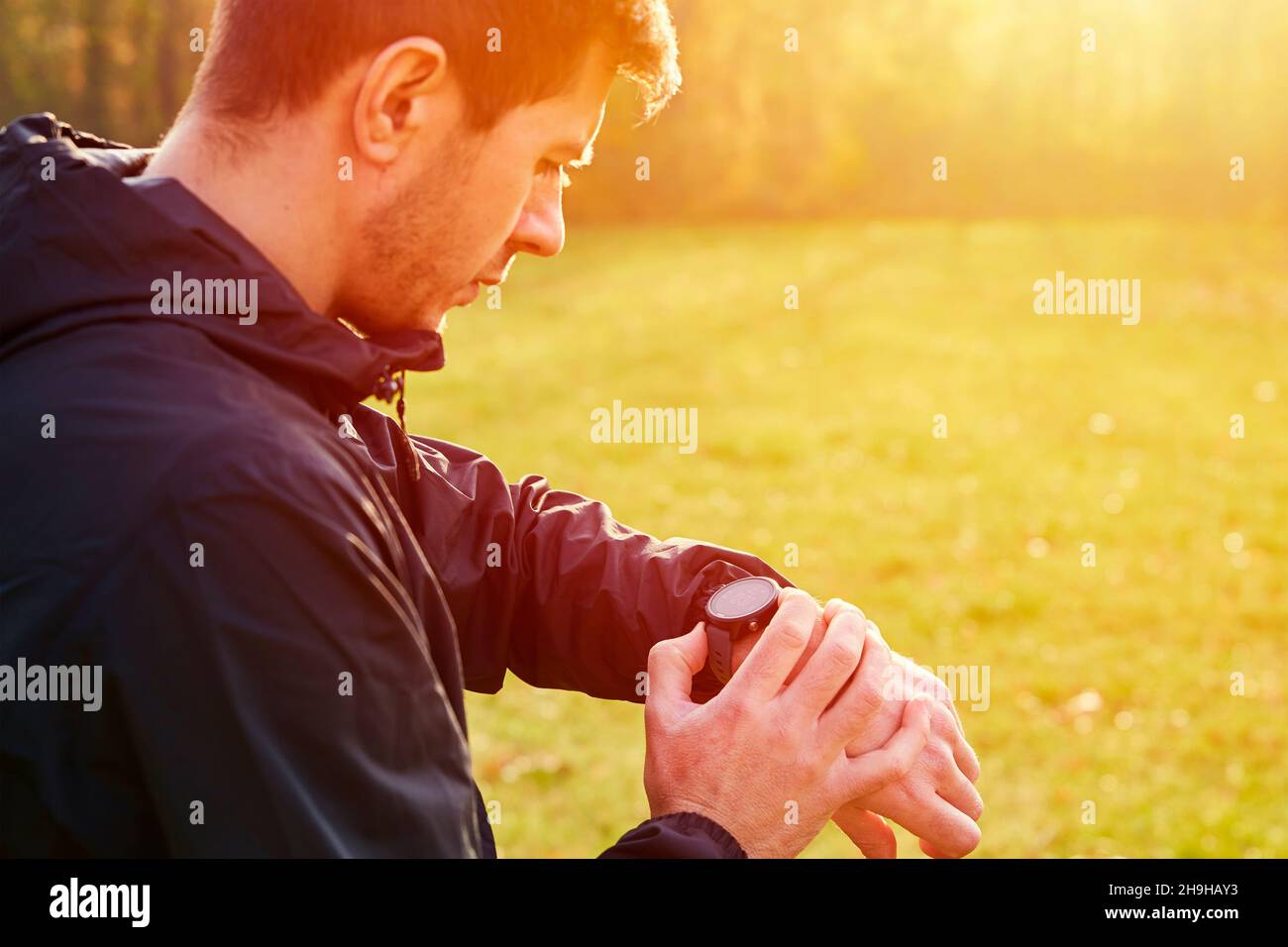 Der Mann verwendet beim Lauftraining eine Sportuhr. Intelligente Uhr für Fitness am Handgelenk Stockfoto