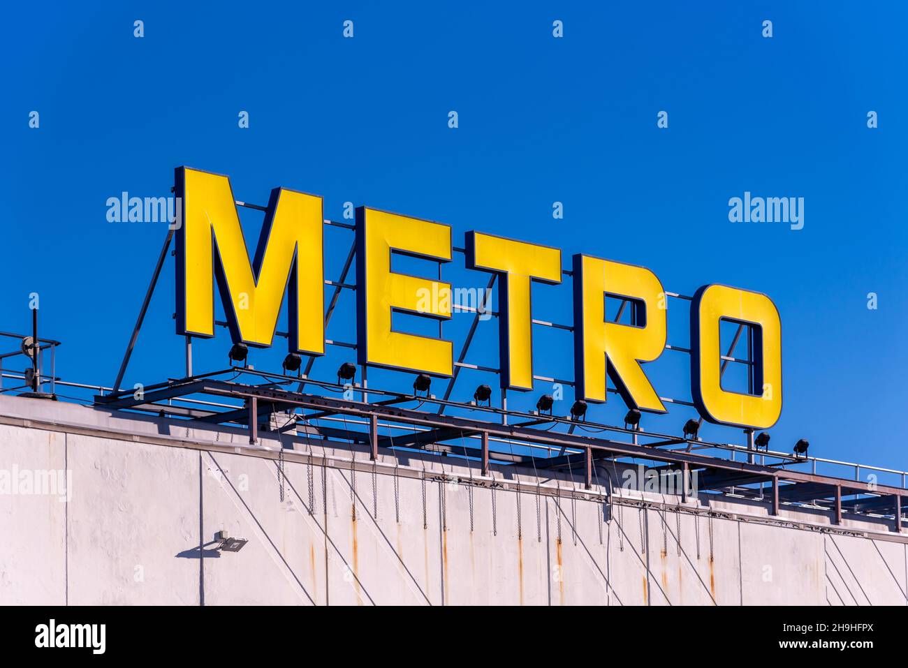 MonCalieri, Turin, Italien - 6. Dezember 2021: Metro-Logo auf dem Gebäude eines Supermarkts am blauen Himmel. Metro Cash and Carry ist ein international führendes Spiel Stockfoto