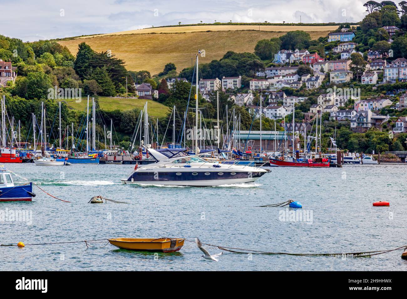 DARTMOUTH, DEVON, Großbritannien - JULI 29 : Blick auf ein leistungsstarkes Motorboot, das am 29. Juli 2012 den Fluss Dart in Dartmouth, Devon, entlanhrt. Drei nicht identifizierte pe Stockfoto