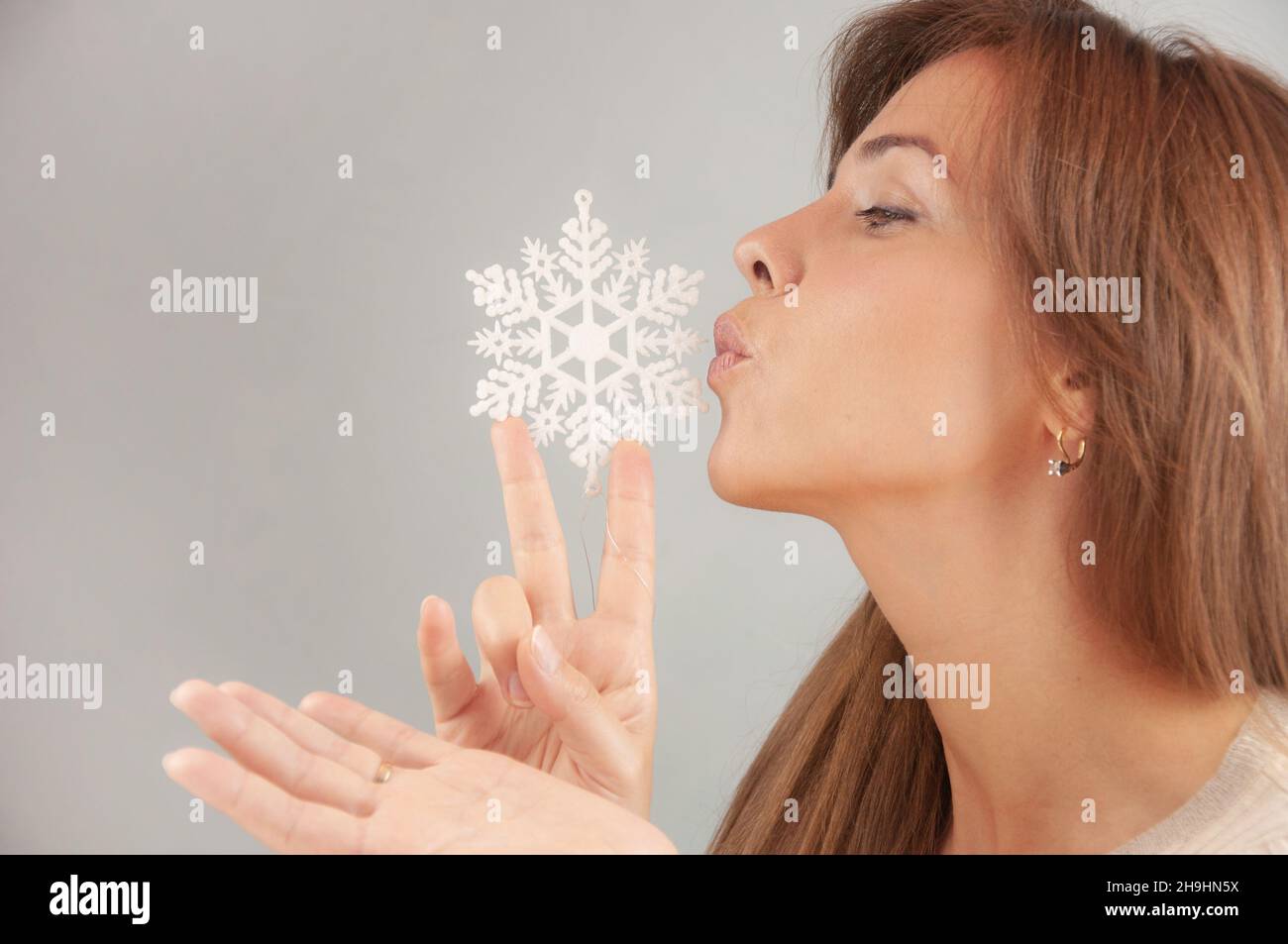 Frau mit Schneeflocke auf grauem Hintergrund. Happy december Konzept. Schnee Winter Hintergrund Stockfoto