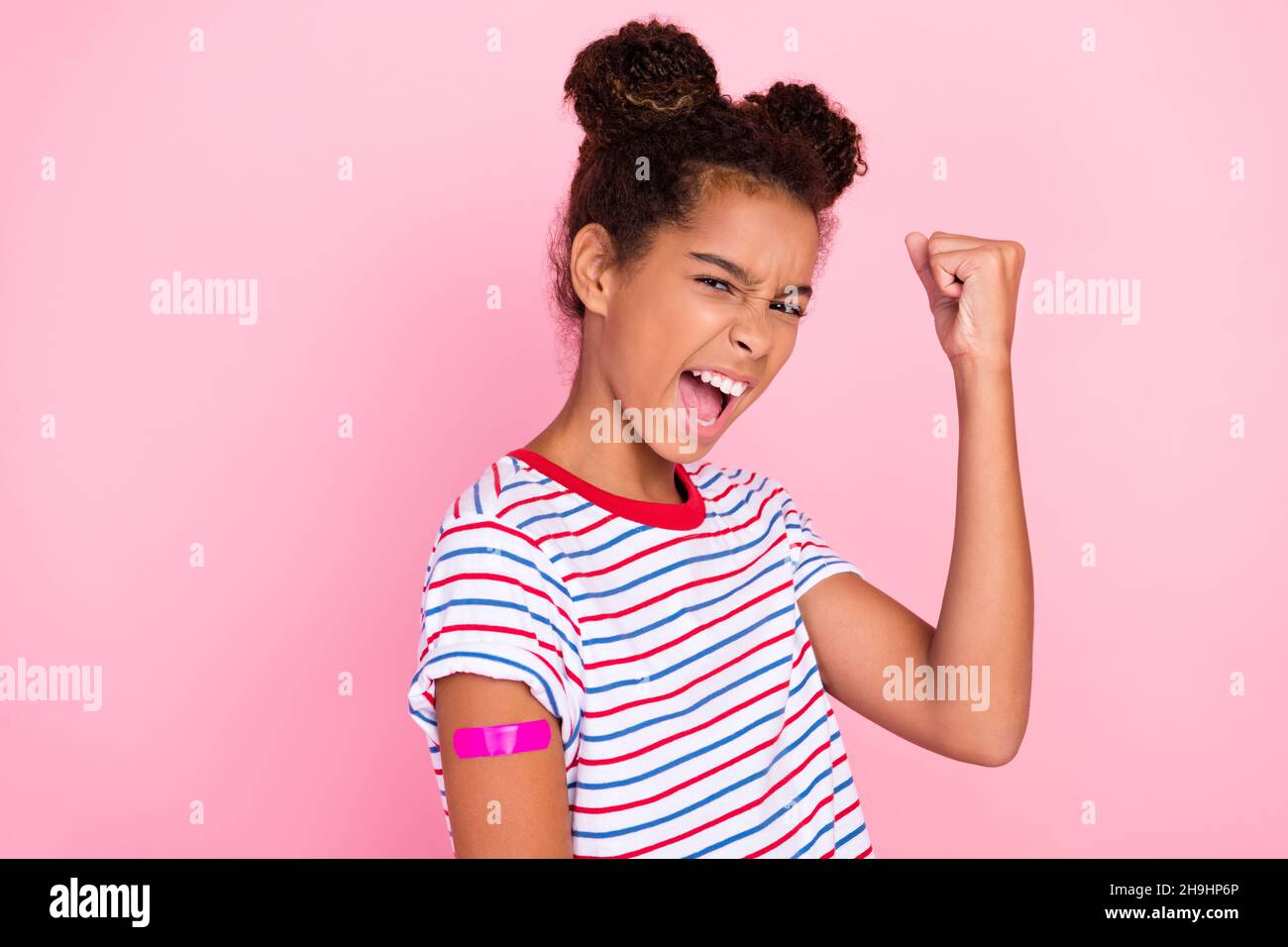 Foto von african american Brown haired kleine Kindheit stilvolle Mädchen tragen T-Shirt Modell Gewinner Impfstoff isoliert auf rosa Hintergrund Stockfoto