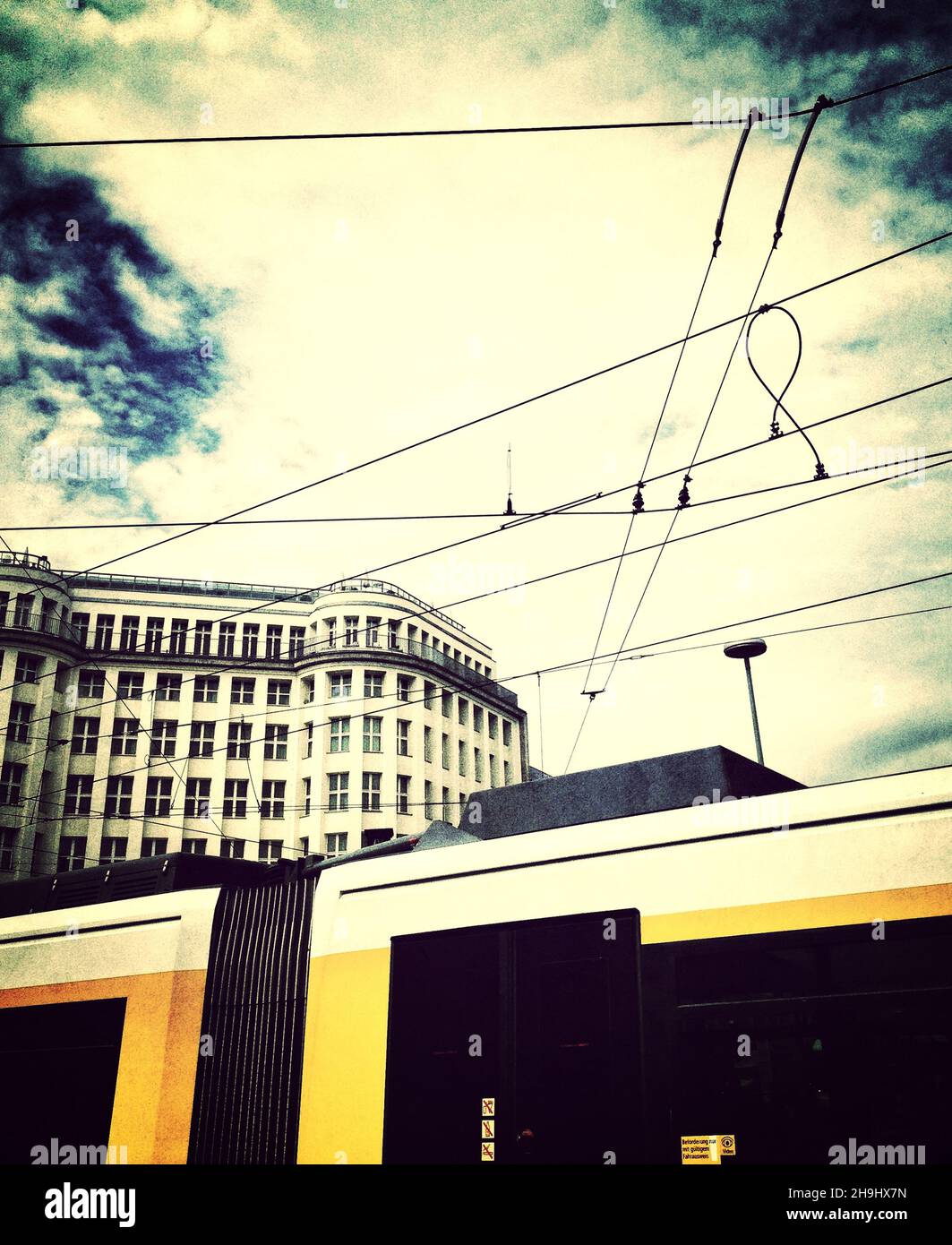 Ein Blick auf das Soho House in Berlin hinter einer Straßenbahn (ein Bild, das mit der Snapseed-App erstellt wurde und Teil einer Reihe von experimentellen Bildern ist, die auf dem iPhone aufgenommen und verarbeitet wurden) Stockfoto