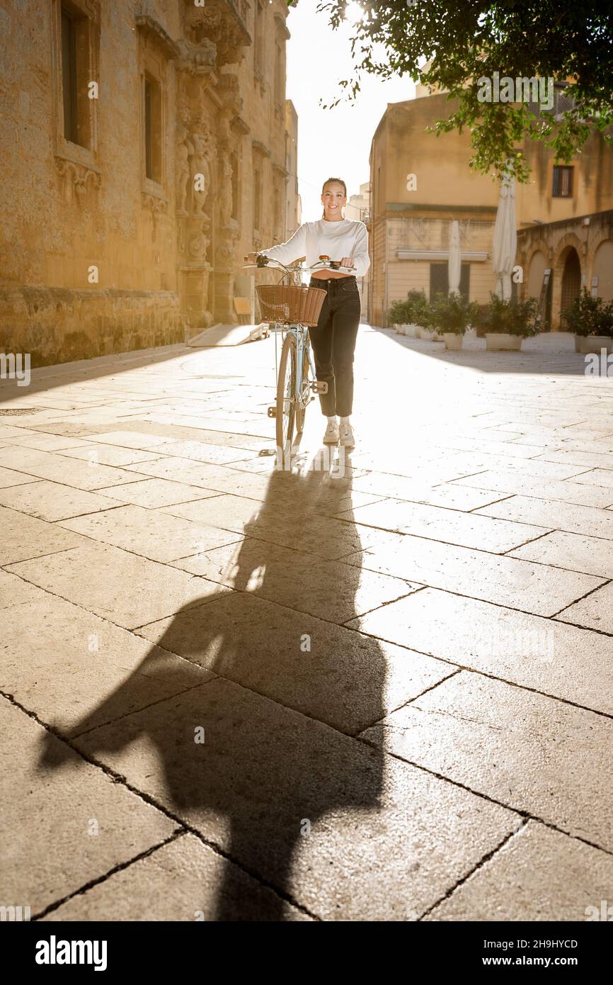Ein junges Mädchen geht an einem sonnigen Tag mit dem Fahrrad Stockfoto
