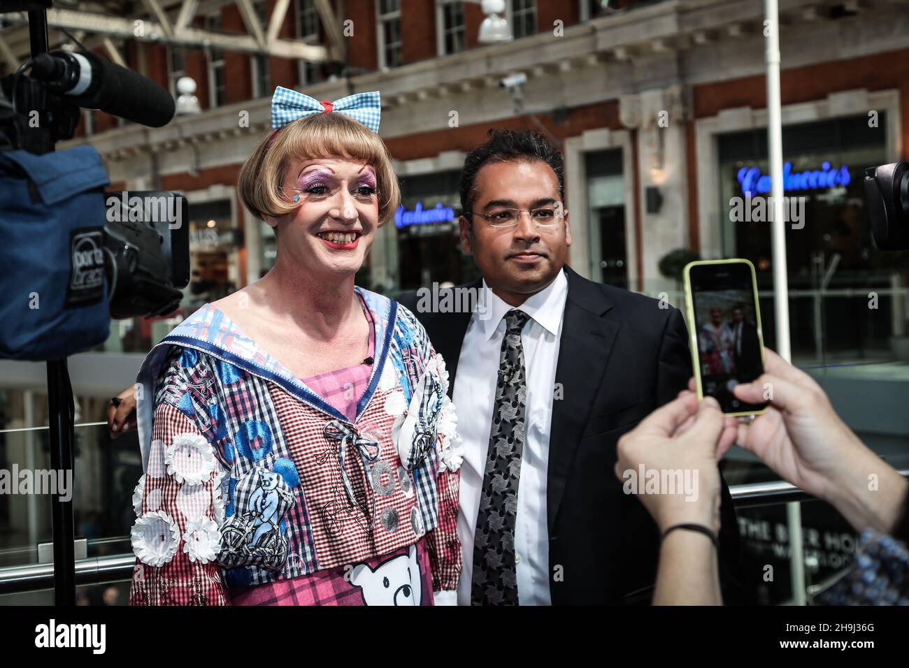 Grayson Perry und Krishnan Guru-Murthy (von Channel 4 News) posieren für Fotos beim Start der landesweiten Ausstellung 'Art Everywhere' in Waterloo Station, London. Stockfoto