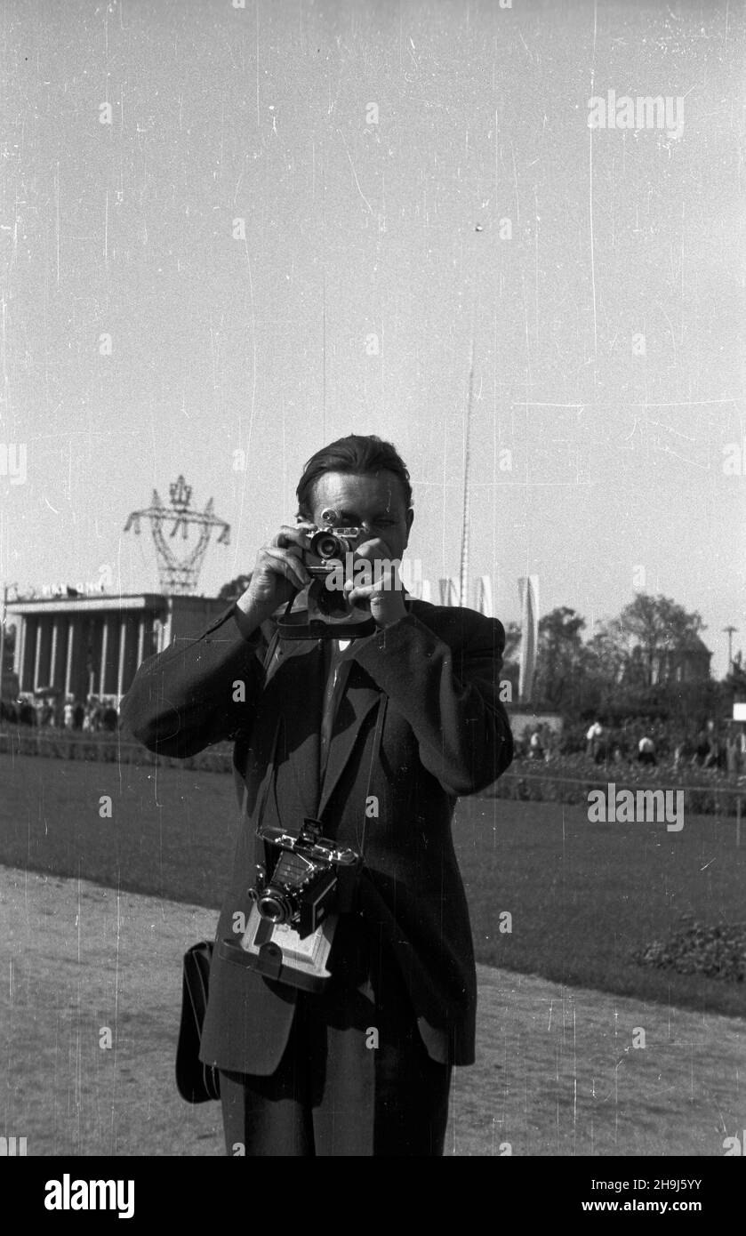 Wroc³aw, 1948-08. W dniach od 21 lipca do 31 paŸdziernika odbywa³a siê Wystawa Ziem Odzyskanych. By³ to cykl wystaw i imprez propagandowych, który mia³ na celu pokazanie osi¹gniêæ Polski Ludowej w odbudowie ziem przy³¹czonych po II wojnie œwiatowej. NZ. Fotoreporter. W tle wie¿a wysokiego napiêcia z emblematem wystawy oraz 106-metrowa iglica. msa PAP Dok³adny dzieñ wydarzenia nieustalony. Breslau, 1948. August. Die Ausstellung wiedererlangte Gebiete, Juli 21 - Oktober 31, war eine Reihe von Propagandaausstellungen und Veranstaltungen, die darauf abzielten, die Errungenschaften des Polens des Volkes bei der Rekonstruktion zu zeigen Stockfoto
