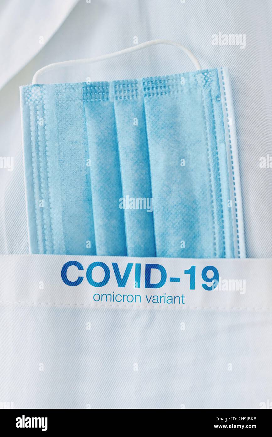 COVID-19 omicron-Variante, medizinische Schutzmaske in weißer Manteltasche, Nahaufnahme mit selektivem Fokus Stockfoto