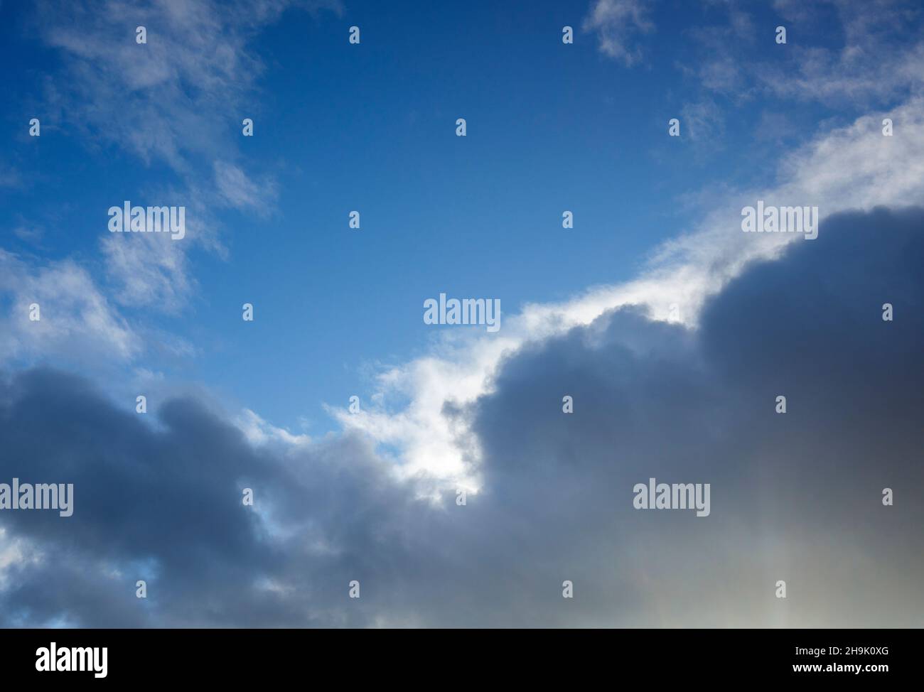 Die Sonne leuchtet von hinten aus dunkler Wolke Stockfoto