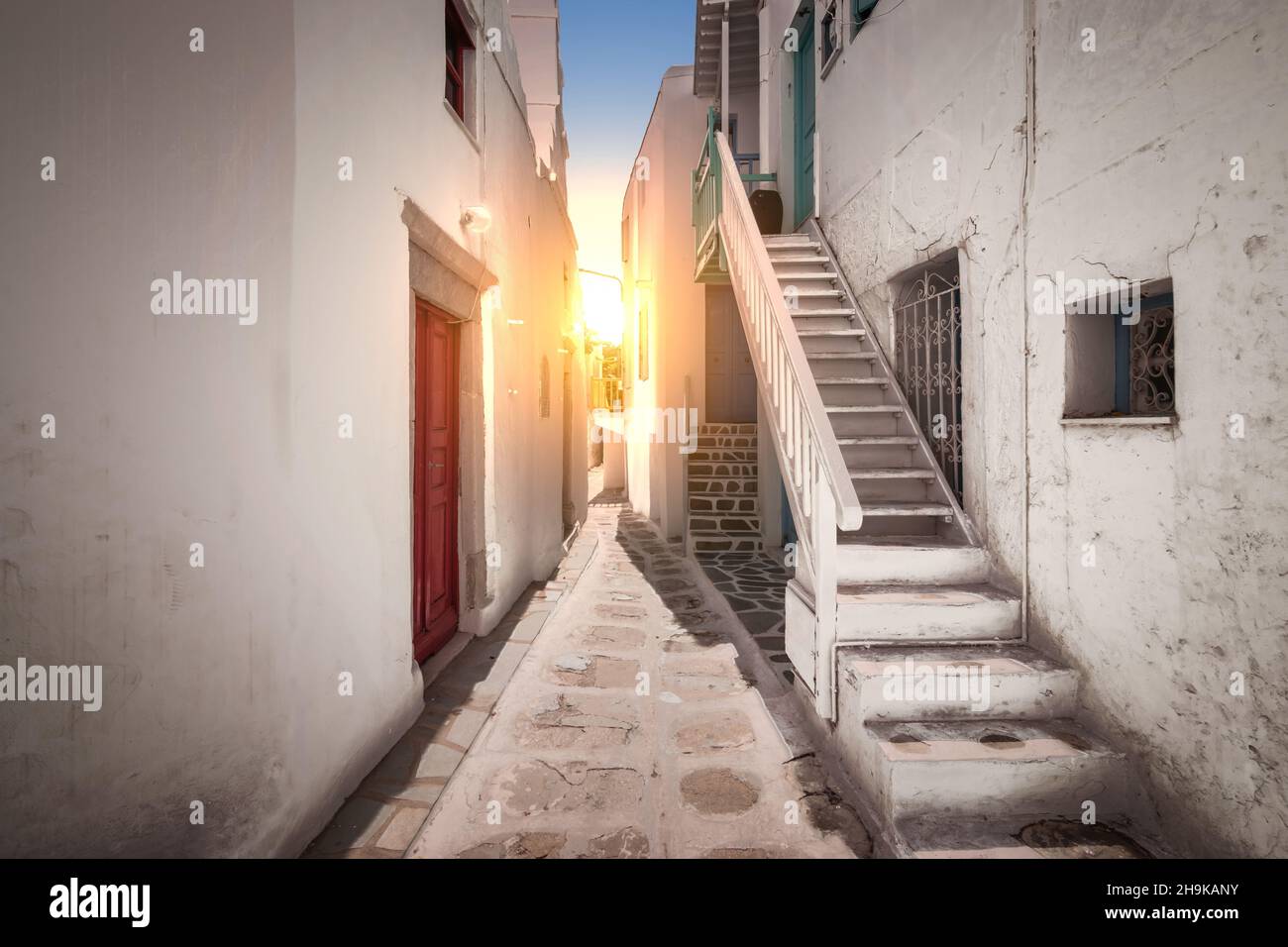 Schmale Gasse in der Stadt Mykonos bei Sonnenuntergang. Stockfoto