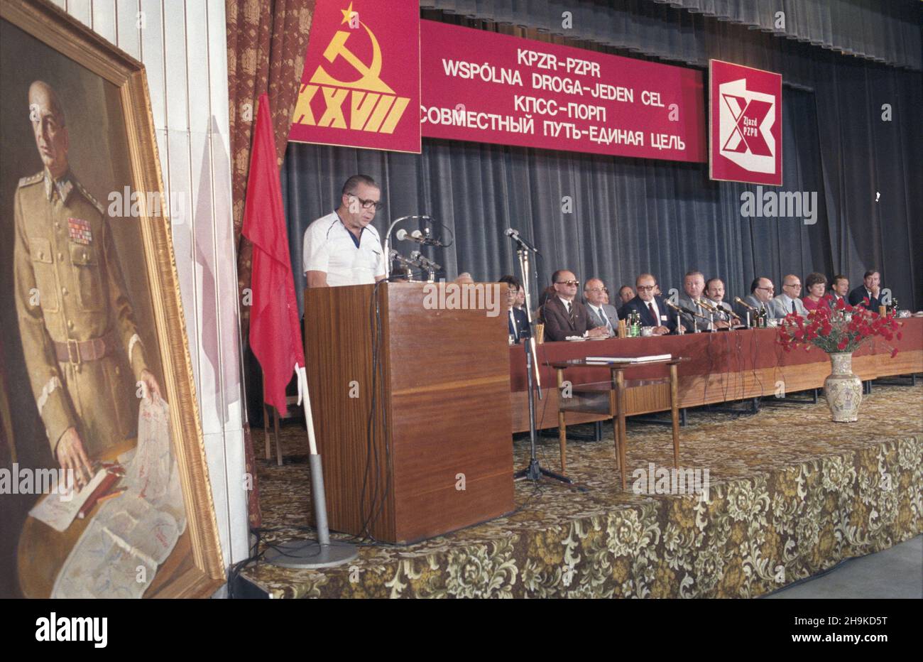 Warszawa 01.07.1986. X Zjazd Polskiej Zjednoczonej Partii Robotniczej (PZPR), w dniach 29,06.-3.07.1986, na który przyjecha³y delegacje zagraniczne. NZ. Spotkanie delegacji radzieckiej z za³og¹ Fabryki Wyrobów Precyzyjnych im. gen. Œwierczewskiego. ZA sto³em siedz¹ m.in.: przewodnicz¹cy Rady Pañstwa PRL i i sekretarz Komitetu Centralnego Polskiej Zjednoczonej Partii Robotniczej (KC PZPR) genera³ Wojciech Jaruzelski (1L), sekretarz generalny Komunistycznej Partii Zwi¹zku Radzieckiego (KPZR) Michai³ Gorbaczow (2L). Przemawia robotnik Stanis³aw Potocki. Z lewej portret olejny gen. Karola Œwiercze Stockfoto