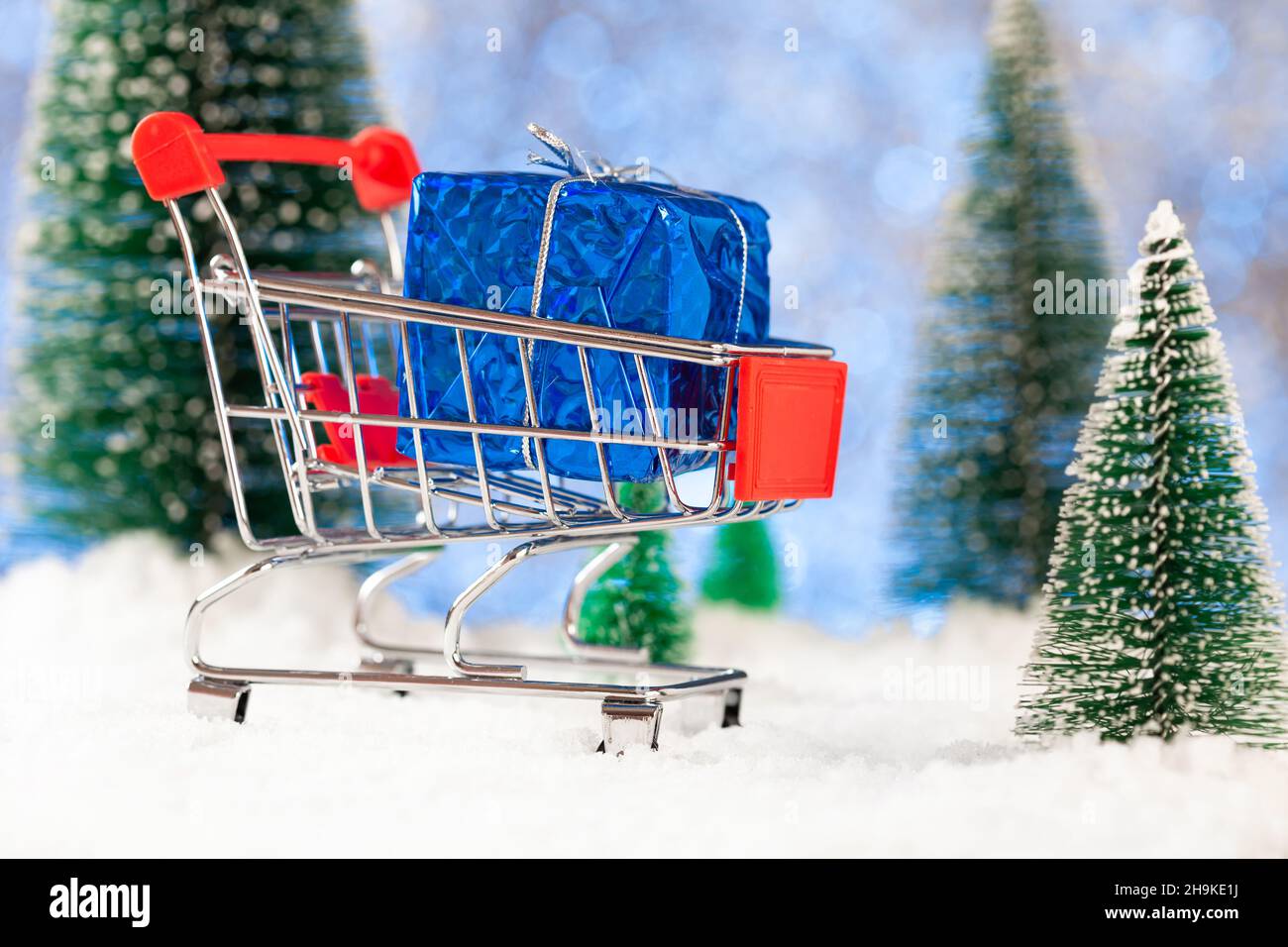 Neujahr und weihnachtseinkäufe für Geschenke, Supermarkt-Korb mit Geschenkbox auf Schnee, Konzept Stockfoto