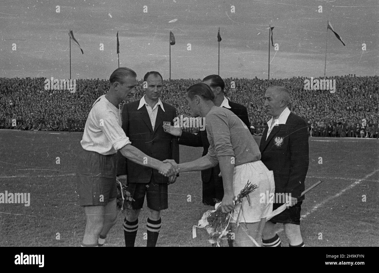 Warszawa, 1948-08-25. Mecz pi³ki no¿nej pomiêdzy reprezentacjami Polski i Jugos³awii (0:1) na stadionie Wojskowego Klubu Sportowego Legia. NZ. Przywitanie kapitanów dru¿yn Tadeusza Porpana (1L) z Miroslavem Brozovicem (3L). Obok sêdziowie liniowi Michalik (2L) i Kmiciñski (1P). ka PAP/Stanis³aw D¹browiecki Warschau, 25. August 1948. Das Fußballspiel zwischen polnischen und jugoslawischen Mannschaften (0:1) im Militärsportverein Legia. Im Bild: kapitän Tadeusza Porpana (1st links) begrüßt Miroslavem Brozovicem (3rd links). Neben ihnen Assistenzreferenten Michalik (2nd links) und Kmicinski (1st rechts). ka Stockfoto
