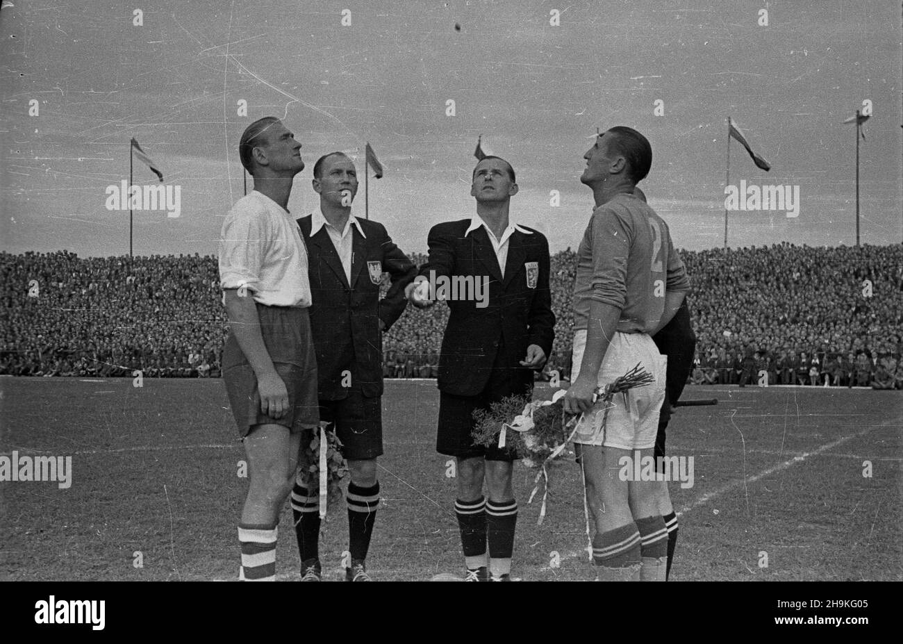Warszawa, 1948-08-25. Mecz pi³ki no¿nej pomiêdzy reprezentacjami Polski i Jugos³awii (0:1) na stadionie Wojskowego Klubu Sportowego Legia. NZ. Losowanie stron boiska. OD lewej: kapitan polskiej dru¿yny Tadeusz Porpan, sêdzia liniowy Michalik (Polska), sêdzia g³ówny Niemcovsky (Czechos³owacja) oraz kapian dru¿yny jugos³owiañskiej Miroslav Brozovic. ka PAP/Stanis³aw D¹browiecki Warschau, 25. August 1948. Das Fußballspiel zwischen polnischen und jugoslawischen Mannschaften (0:1) im Militärsportverein Legia. Abgebildet: Zeichnen der Pitchseiten. Von links: Der polnische Mannschaftskapitän Tadeusz Porpan, Schiedsrichter-Assistent Stockfoto
