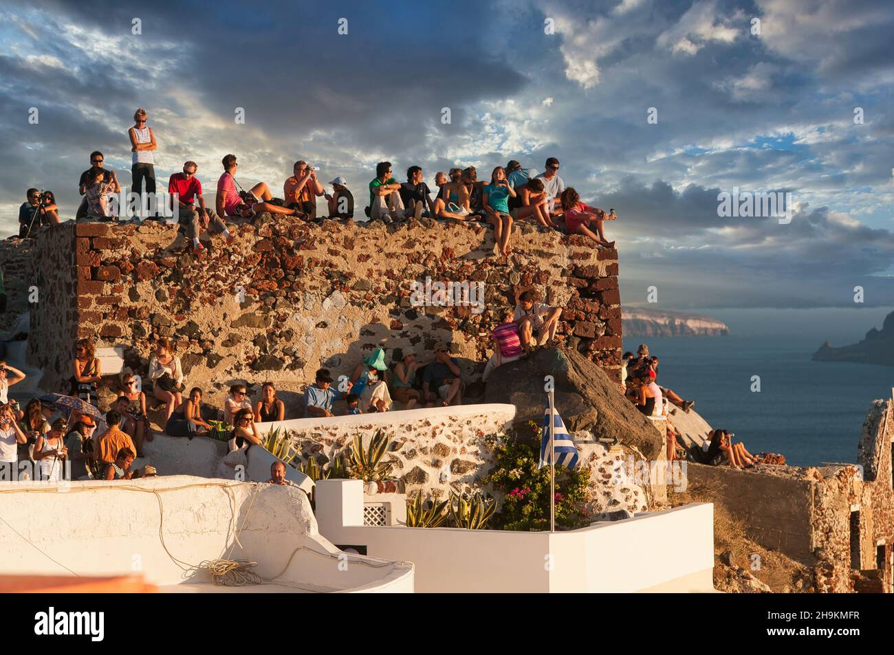 Reisende, die den Sonnenuntergang in Oia, Santorini, Griechenland, beobachten. Gruppe von Menschen, die den Sonnenuntergang in Oia, Griechenland, beobachten Stockfoto
