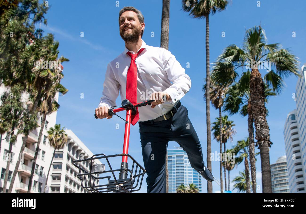 Eine neue Art des Scotings. Glücklicher Kerl fahren Elektroroller auf der Straße. Scooter-E-Scooter Stockfoto