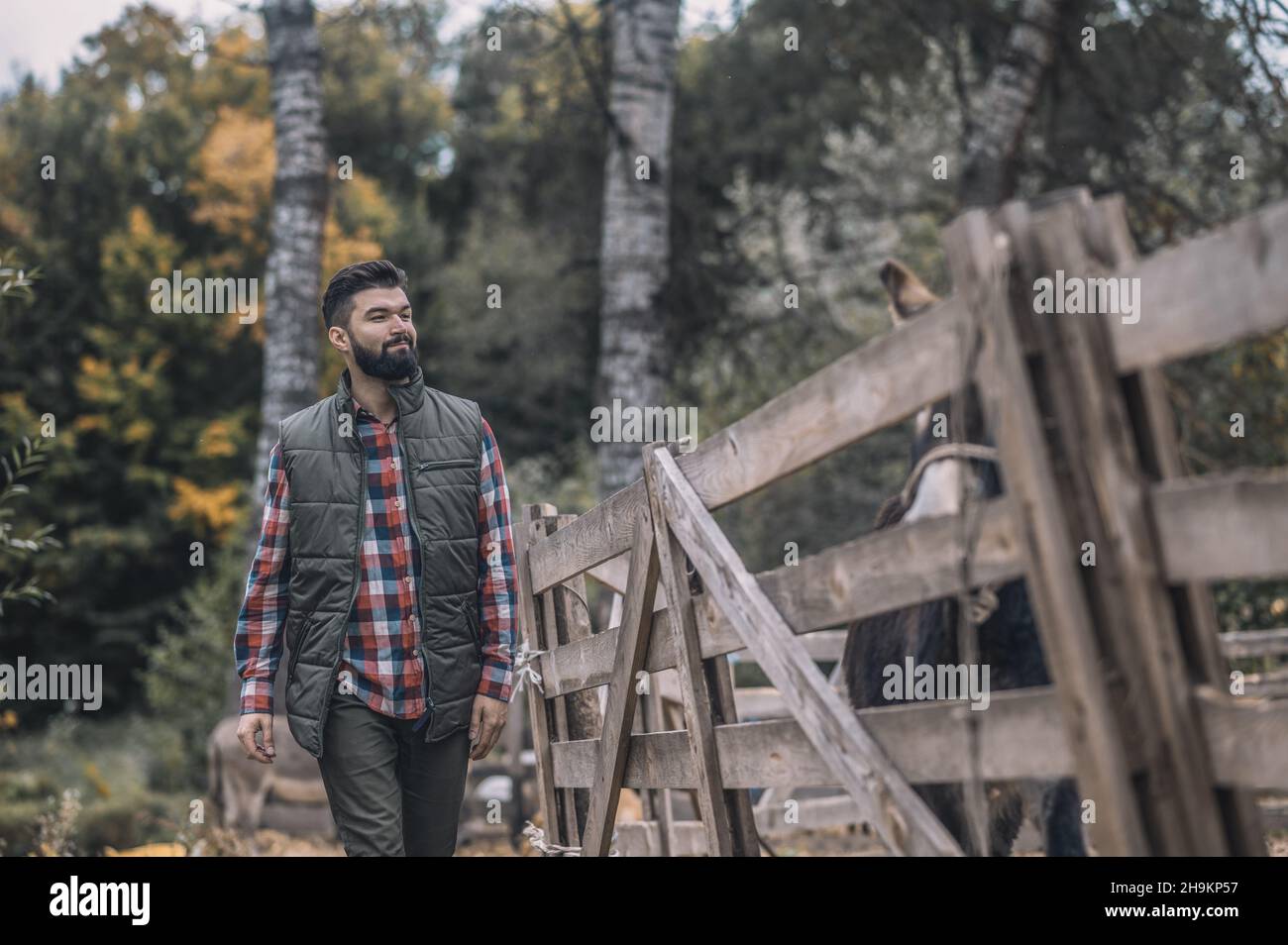 Ein Mann im karierten Gürtel und einer Weste, der auf dem Land unterwegs ist Stockfoto