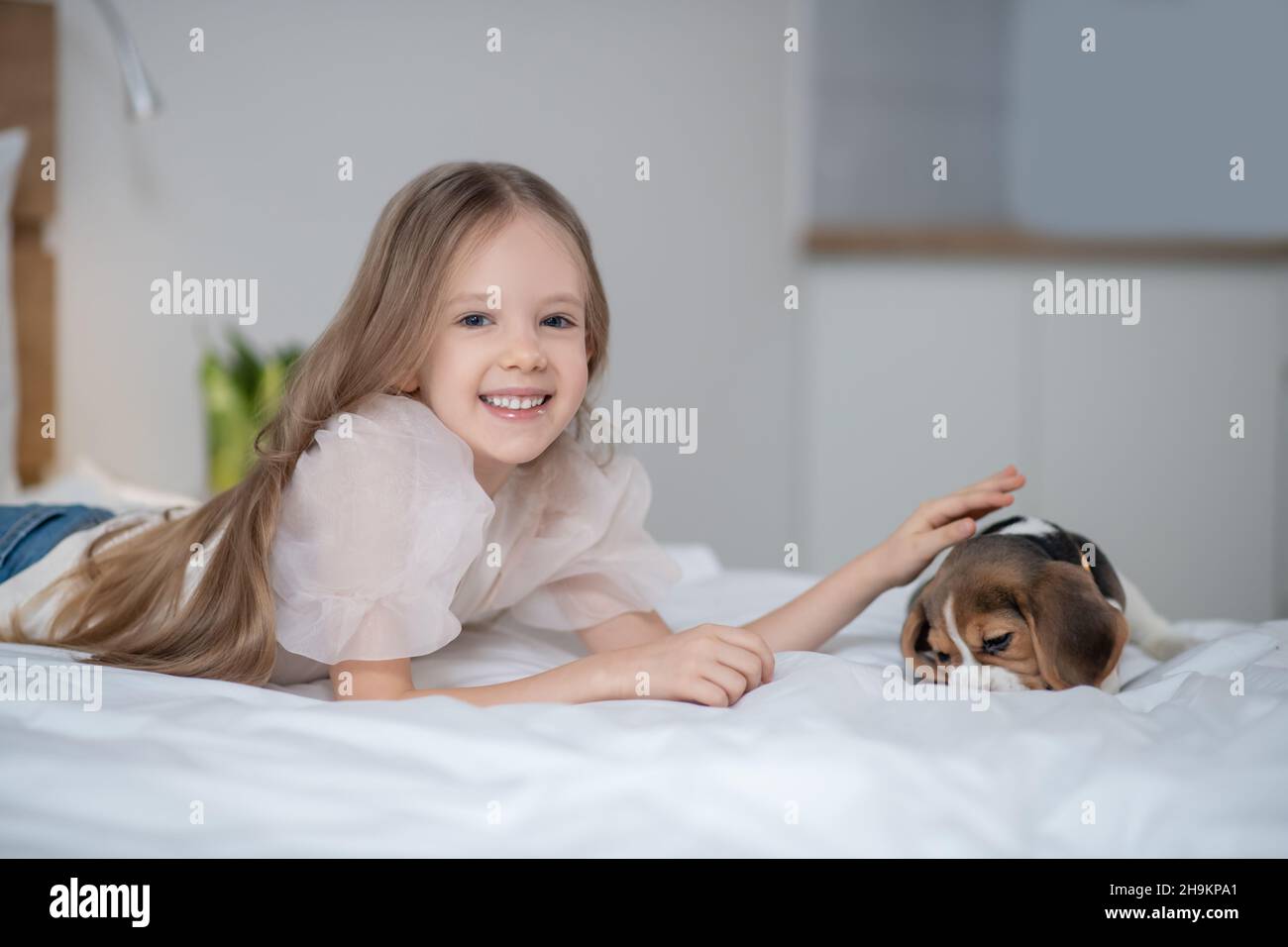 Fröhlich liebenswert kleines Mädchen streichelte ihren Welpen Stockfoto