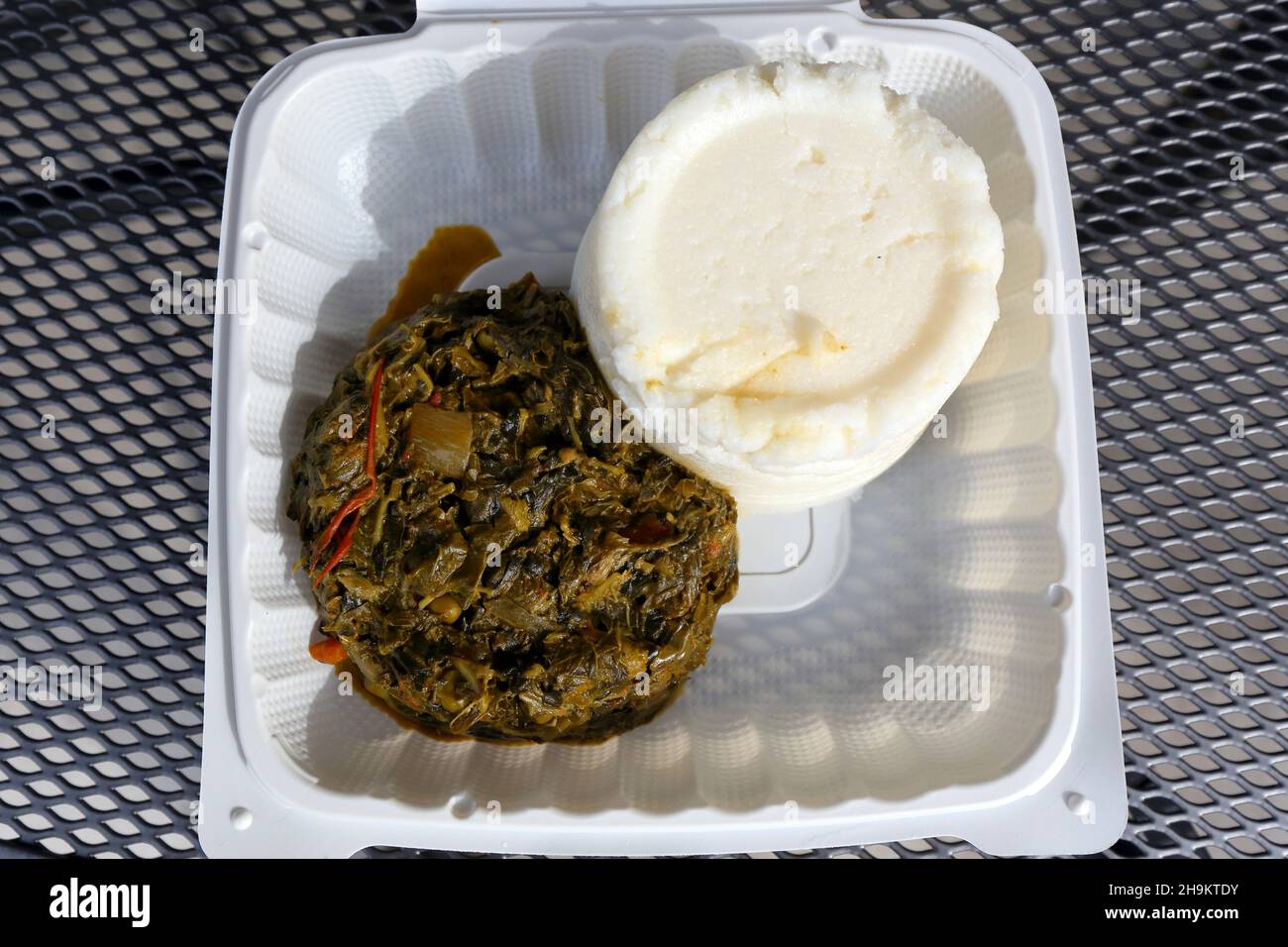Ugali diente mit Sukuwa Wiki in der Moyo Kitchen an der Spice Bridge, Tukwila, Washington. Polenta mit Grünkiefereintopf mit Tomaten und Gewürzen. Stockfoto