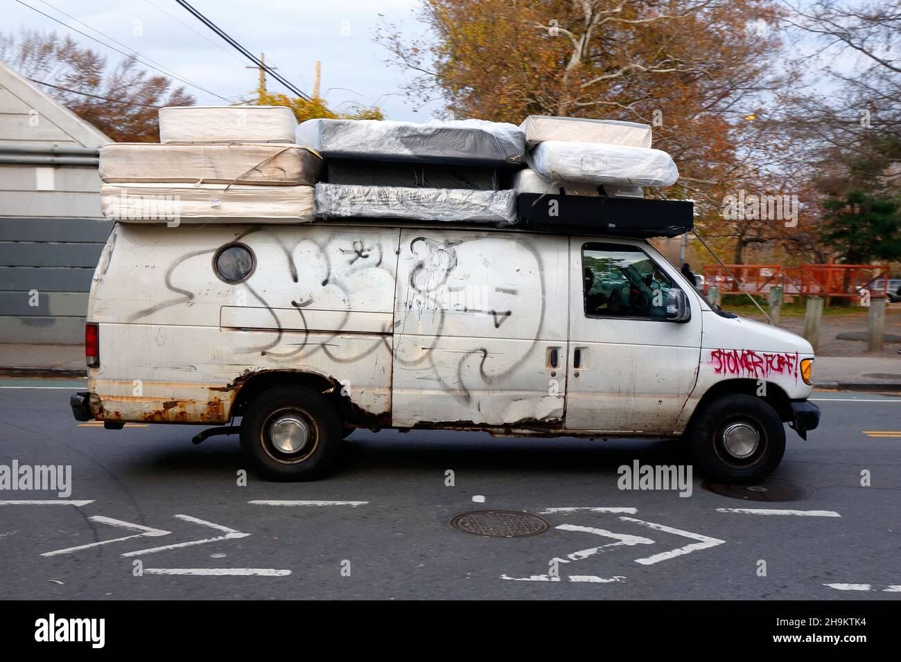 Ein Van transportiert gebrauchte Matratzen, die im Müll gefunden wurden, an einen Ort, an dem sie renoviert und als gelbe, wiederaufgebaute Matratze weiterverkauft werden. Stockfoto