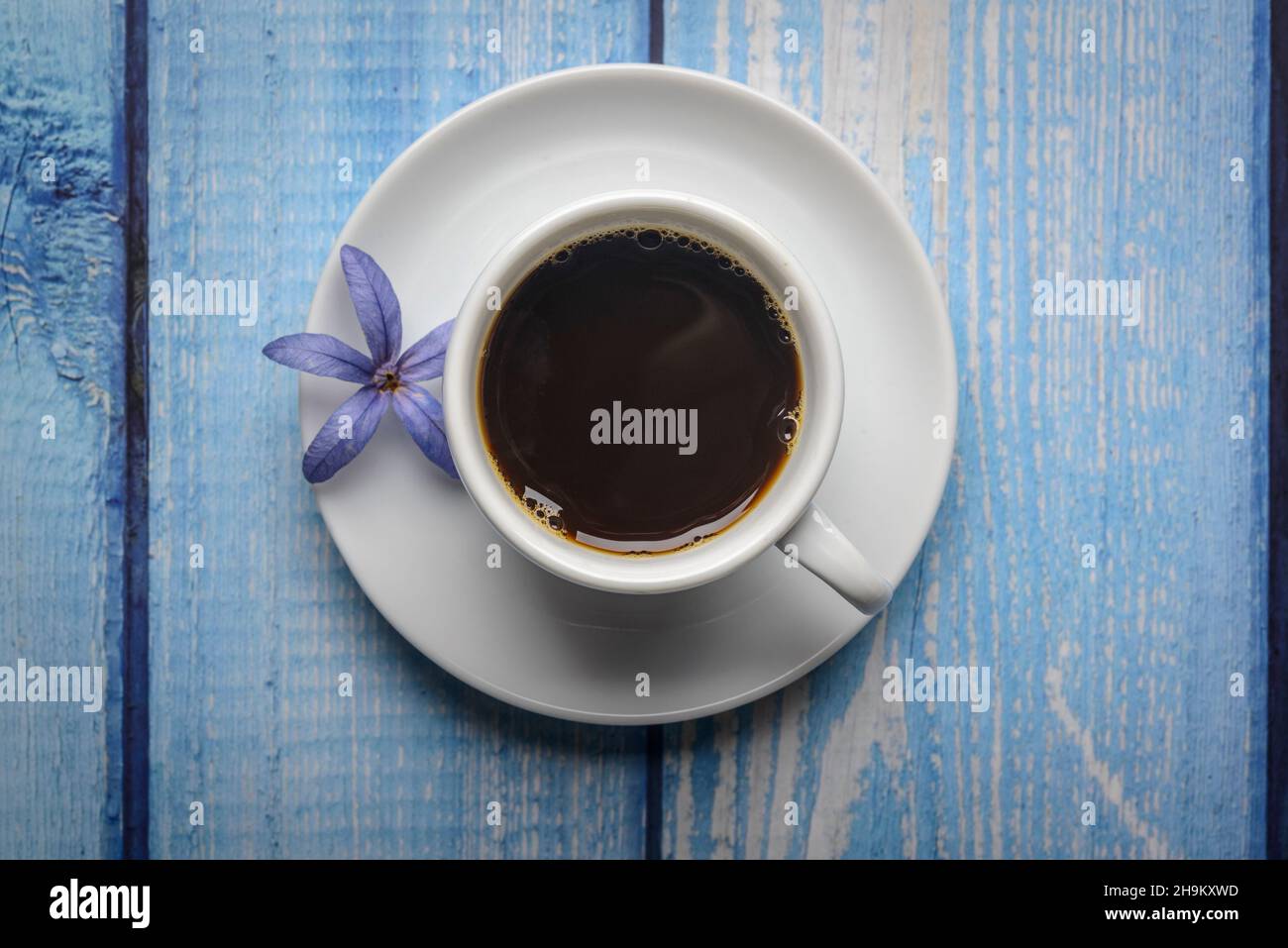 Kaffee. Weiße Tasse Kaffee auf einem blauen Holztisch. Stockfoto