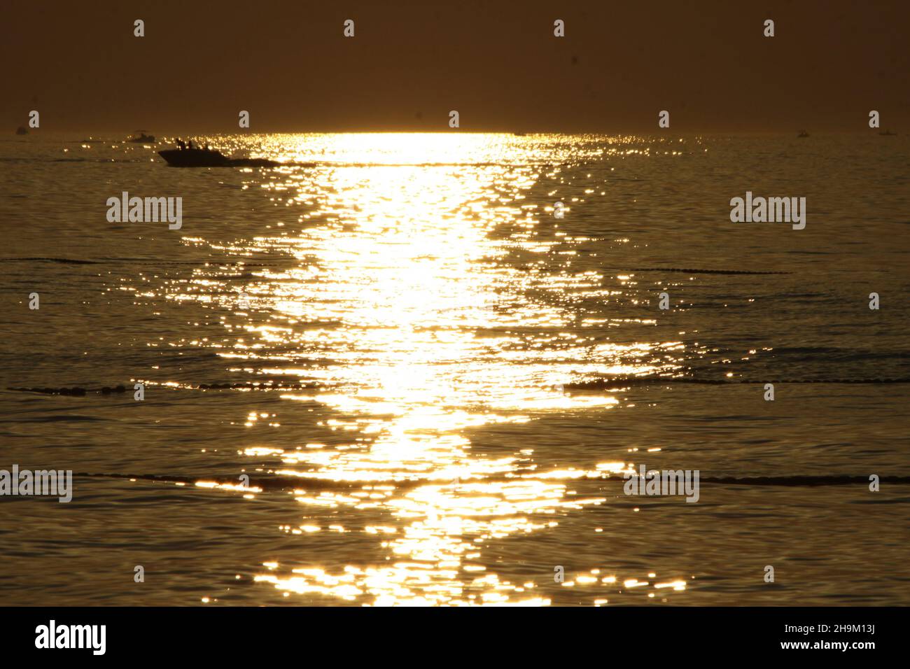Das Muster der Wellen im Meer während des Sonnenuntergangs am Strand. Stockfoto