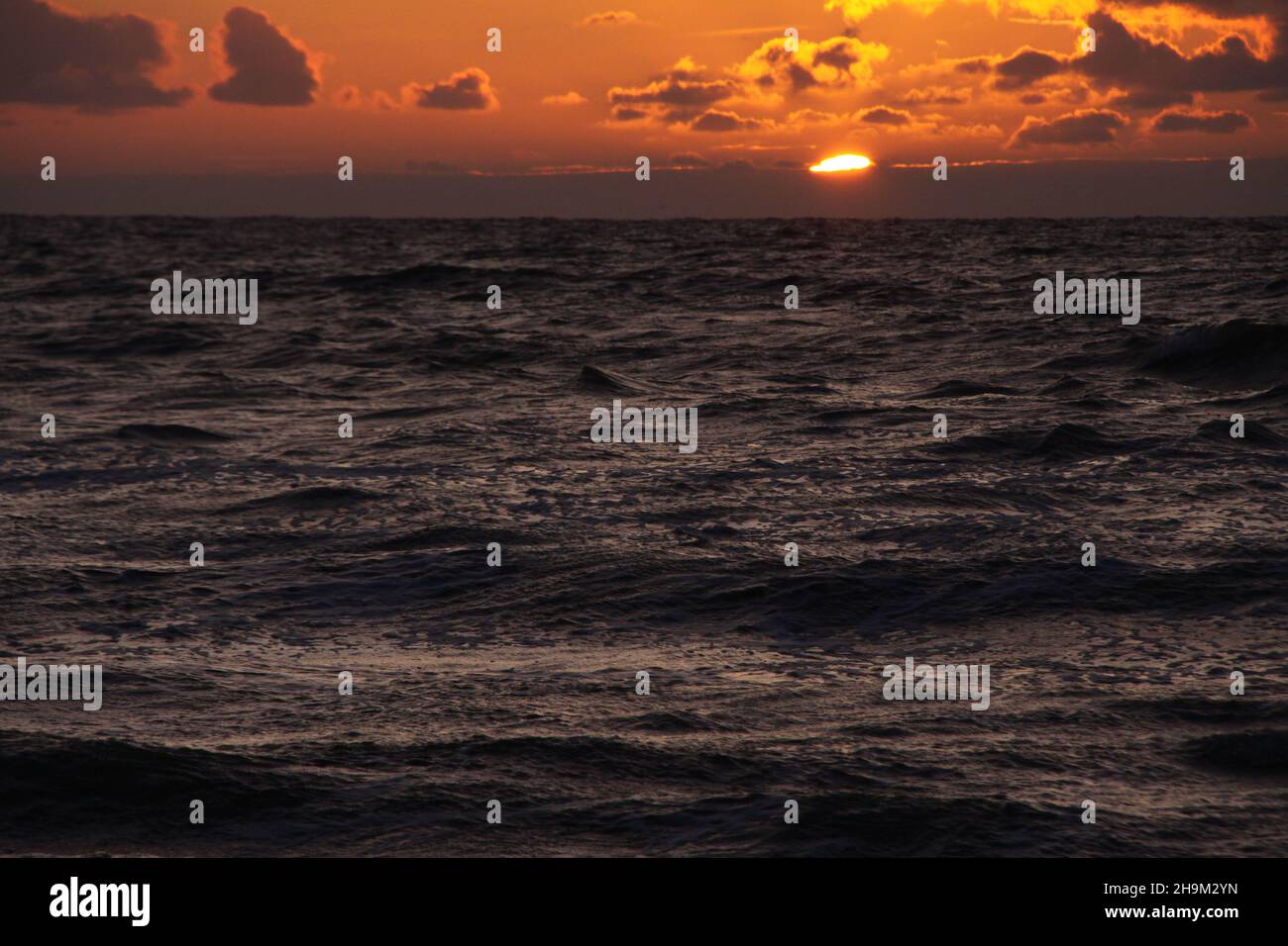 Das Muster der Wellen im Meer während des Sonnenuntergangs am Strand. Goldene Stunde. Stockfoto