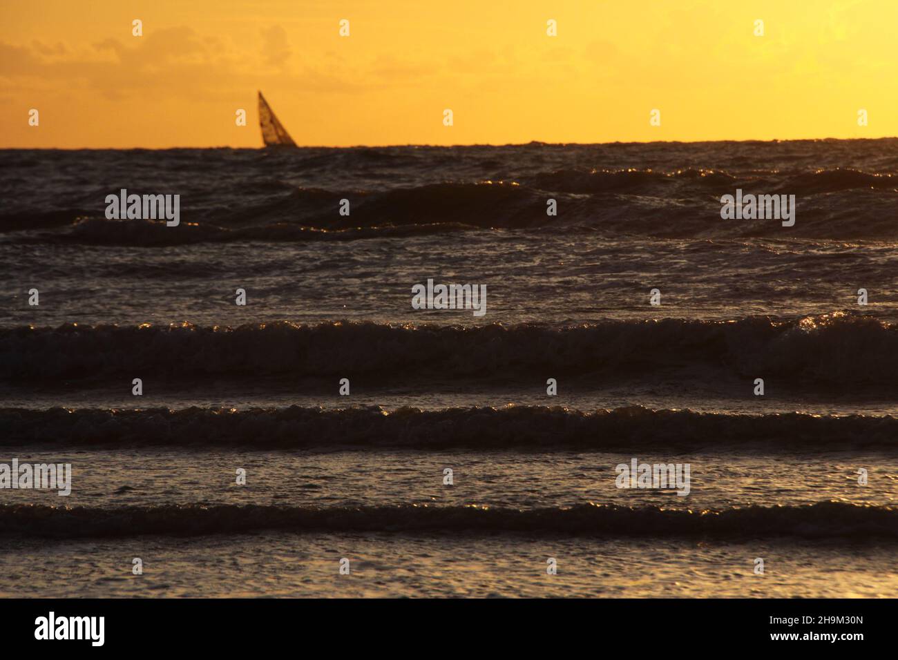 Das Muster der Wellen im Meer während des Sonnenuntergangs am Strand. Goldene Stunde. Stockfoto
