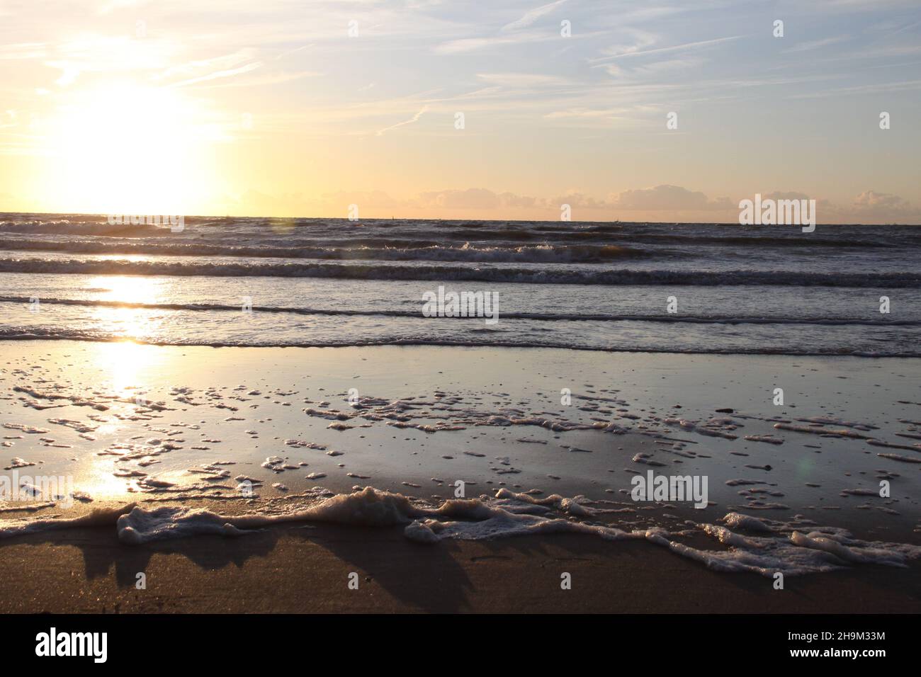 Das Muster der Wellen im Meer während des Sonnenuntergangs am Strand. Goldene Stunde. Stockfoto