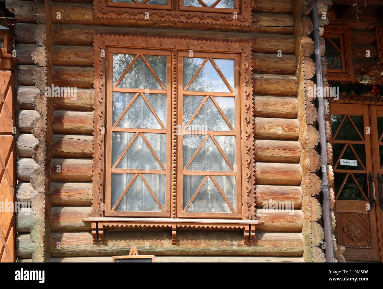 Ein Fenster in einem Haus aus Baumstämmen. Stockfoto