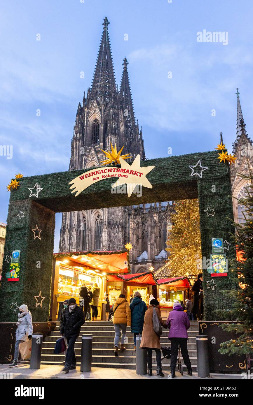 Kölner Dom mit Weihnachtsmarkt am Winterabend Stockfoto