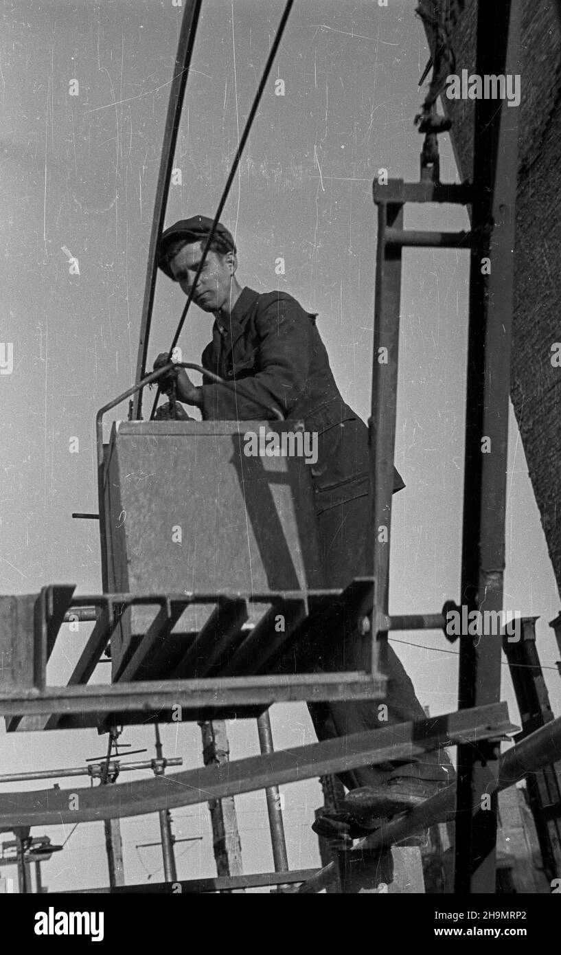 Warszawa, 1948-10. Ulica Marsza³kowska bêdzie cztery razy szersza. Przy likwidowaniu rumowisk jej zachodniej czêœci pracuj¹ brygady Powszechnej Organizacji S³u¿BA Polsce (SP). Usuwanie gruzu u³atwia zastosowanie kolejki linowej pomys³u in¿. Grodeckiego. NZ. Odbieranie wagonika z gruzem. mw PAP Dok³adny dzieñ wydarzenia nieustalony. Warschau, 1948. Okt. Brigaden des Dienstes der Massenorganisation nach Polen, die Trümmer im westlichen Teil der Marszalkowska-Straße entfernen. Der Schutt wird mit Hilfe eines Förderers des Ingenieurs Grodecki entfernt. Sobald der Schutt geräumt ist, wird die Straße vier tim sein Stockfoto