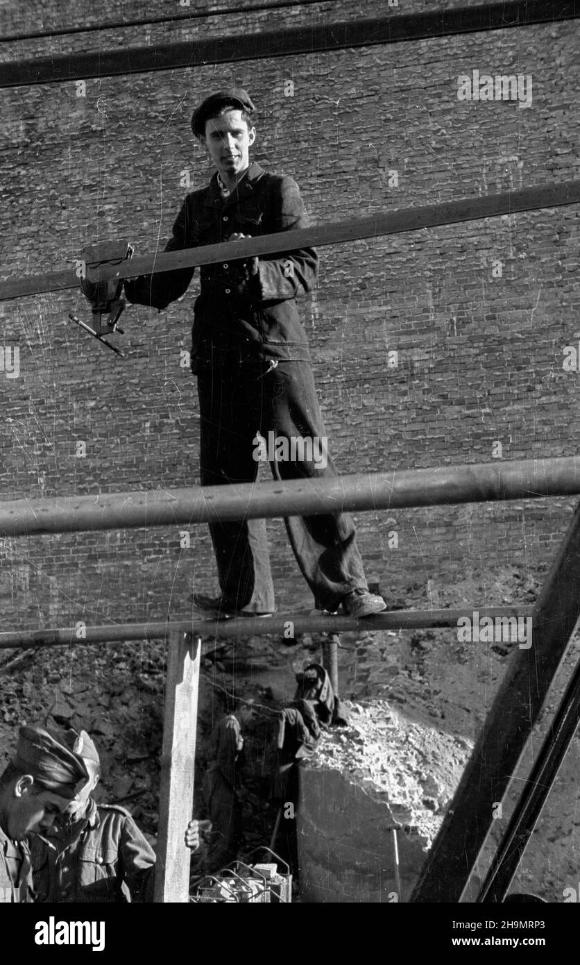 Warszawa, 1948-10. Ulica Marsza³kowska bêdzie cztery razy szersza. Przy likwidowaniu rumowisk jej zachodniej czêœci pracuj¹ brygady Powszechnej Organizacji S³u¿BA Polsce (SP). Usuwanie gruzu u³atwia zastosowanie kolejki linowej pomys³u in¿. Grodeckiego. mw PAP Dok³adny dzieñ wydarzenia nieustalony. Warschau, 1948. Okt. Brigaden des Dienstes der Massenorganisation nach Polen, die Trümmer im westlichen Teil der Marszalkowska-Straße entfernen. Der Schutt wird mit Hilfe eines Förderers des Ingenieurs Grodecki entfernt. Sobald die Straße von Trümmern geräumt ist, wird sie vier Mal breiter. mw PAP Stockfoto