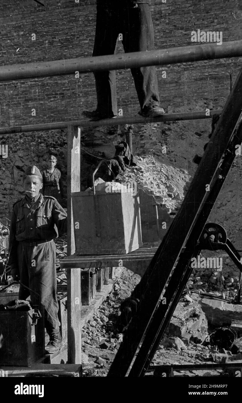 Warszawa, 1948-10. Ulica Marsza³kowska bêdzie cztery razy szersza. Przy likwidowaniu rumowisk jej zachodniej czêœci pracuj¹ brygady Powszechnej Organizacji S³u¿BA Polsce (SP). Usuwanie gruzu u³atwia zastosowanie kolejki linowej pomys³u in¿. Grodeckiego. NZ. Junacy przy wagoniku transportuj¹cym gruz. mw PAP Dok³adny dzieñ wydarzenia nieustalony. Warschau, 1948. Okt. Brigaden des Dienstes der Massenorganisation nach Polen, die Trümmer im westlichen Teil der Marszalkowska-Straße entfernen. Der Schutt wird mit Hilfe eines Förderers des Ingenieurs Grodecki entfernt. Einmal von Trümmern befreit, wird die Straße zwil Stockfoto