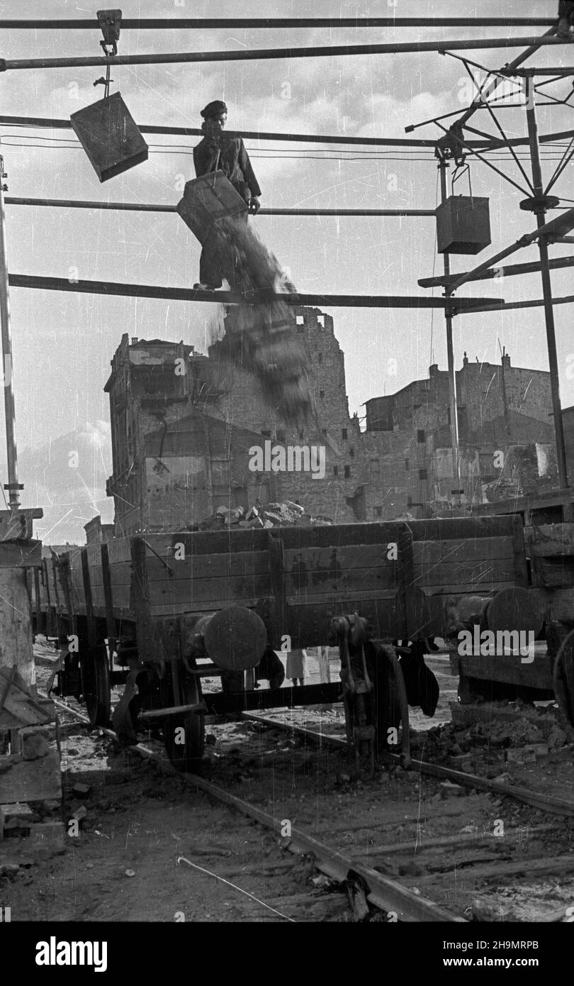 Warszawa, 1948-10. Ulica Marsza³kowska bêdzie cztery razy szersza. Przy likwidowaniu rumowisk jej zachodniej czêœci pracuj¹ brygady Powszechnej Organizacji S³u¿BA Polsce (SP). Usuwanie gruzu u³atwia zastosowanie kolejki linowej pomys³u in¿. Grodeckiego. NZ. Wysypywanie gruzu do podstawionych wagonów. mw PAP Dok³adny dzieñ wydarzenia nieustalony. Warschau, 1948. Okt. Brigaden des Dienstes der Massenorganisation nach Polen, die Trümmer im westlichen Teil der Marszalkowska-Straße entfernen. Der Schutt wird mit Hilfe eines Förderers des Ingenieurs Grodecki entfernt. Einmal von Trümmern geräumt, die Straße wi Stockfoto