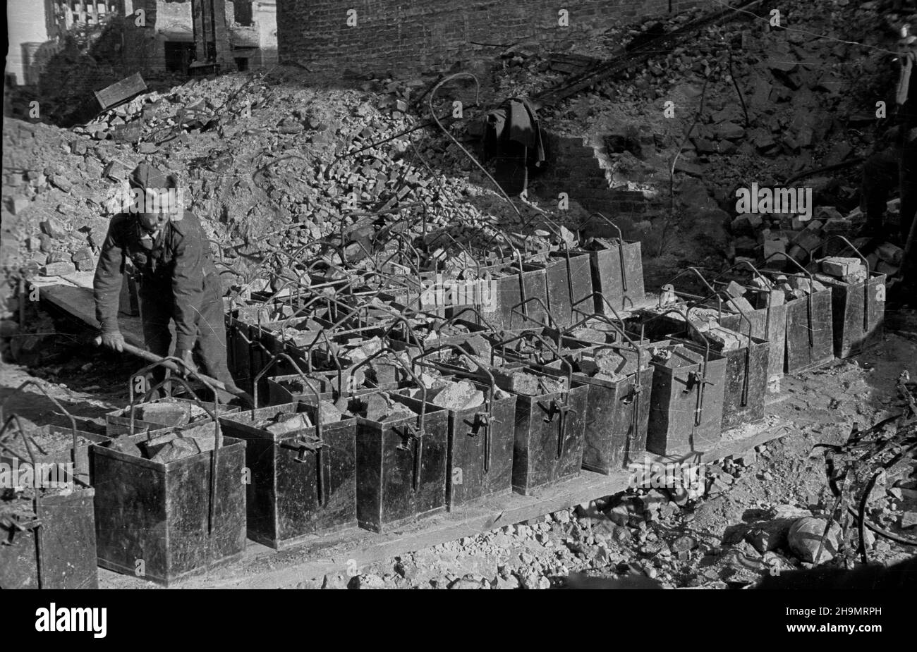 Warszawa, 1948-10. Ulica Marsza³kowska bêdzie cztery razy szersza. Przy likwidowaniu rumowisk jej zachodniej czêœci pracuj¹ brygady Powszechnej Organizacji S³u¿BA Polsce (SP). Usuwanie gruzu u³atwia zastosowanie kolejki linowej pomys³u in¿. Grodeckiego. NZ. Wagoniki kolejki nape³nione gruzem. mw PAP Dok³adny dzieñ wydarzenia nieustalony. Warschau, 1948. Okt. Brigaden des Dienstes der Massenorganisation nach Polen, die Trümmer im westlichen Teil der Marszalkowska-Straße entfernen. Der Schutt wird mit Hilfe eines Förderers des Ingenieurs Grodecki entfernt. Nach der Räumung der Trümmer wird die Straße sein Stockfoto