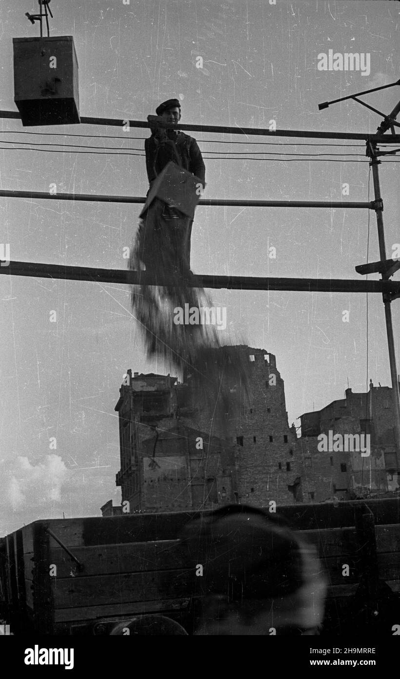 Warszawa, 1948-10. Ulica Marsza³kowska bêdzie cztery razy szersza. Przy likwidowaniu rumowisk jej zachodniej czêœci pracuj¹ brygady Powszechnej Organizacji S³u¿BA Polsce (SP). Usuwanie gruzu u³atwia zastosowanie kolejki linowej pomys³u in¿. Grodeckiego. NZ. Wysypywanie gruzu do podstawionych wagonów. mw PAP Dok³adny dzieñ wydarzenia nieustalony. Warschau, 1948. Okt. Brigaden des Dienstes der Massenorganisation nach Polen, die Trümmer im westlichen Teil der Marszalkowska-Straße entfernen. Der Schutt wird mit Hilfe eines Förderers des Ingenieurs Grodecki entfernt. Einmal von Trümmern geräumt, die Straße wi Stockfoto