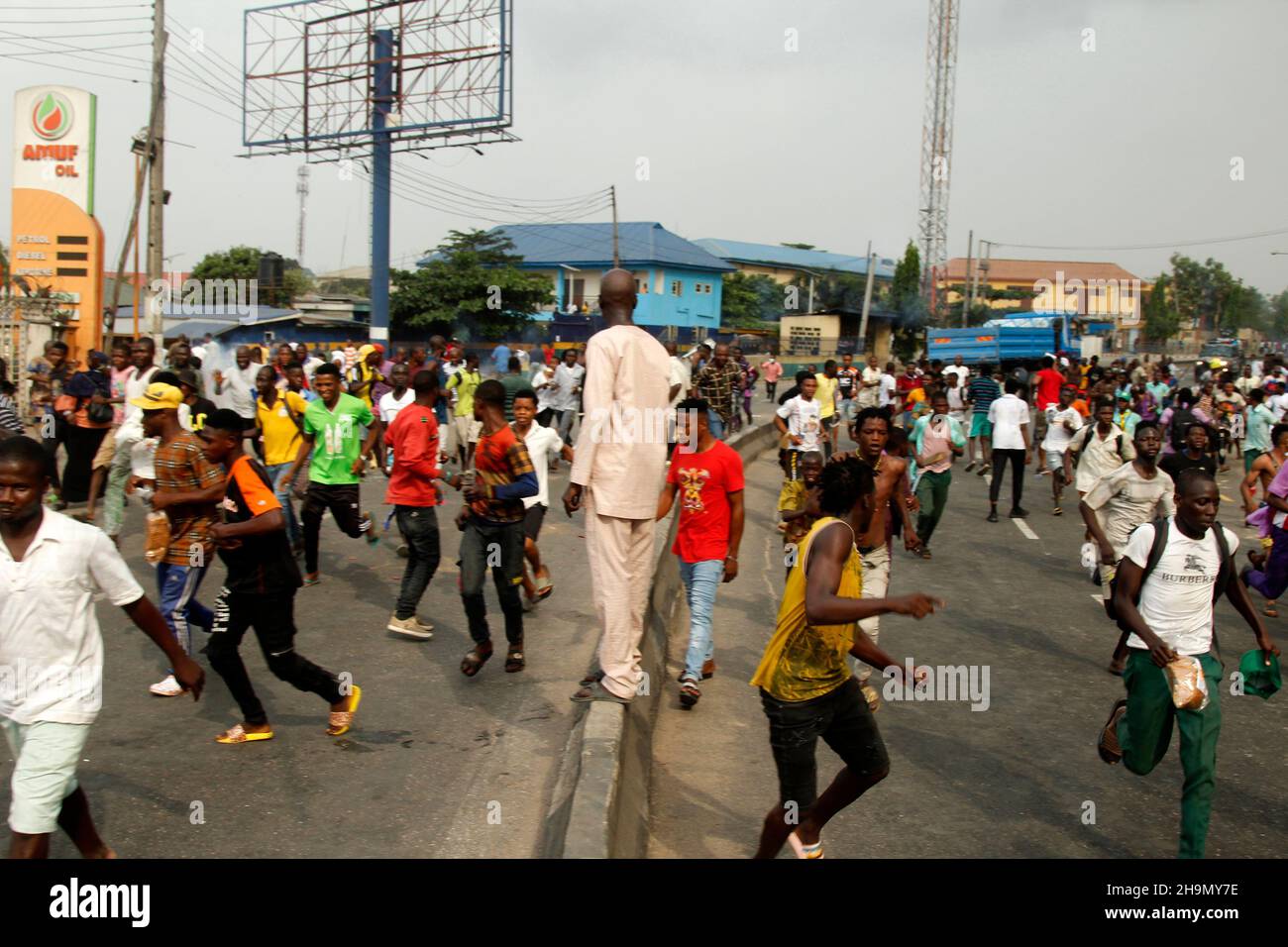 Lagos, Nigeria, 7th. Dezember 2021. Demonstranten fliehen vor Polizeitrengas am Gymnasium in Ojodu, Lagos, Nigeria, wo ein Lieferwagen, der angeblich von Verkehrsbeamten verfolgt wurde, einige Studenten tötete, die von der Schule zurückkehrten. Während der Augenzeuge sagte, dass mindestens 17 Schüler starben, bestätigte die Polizei am Dienstag, dass drei Tote, 12 Verletzte, bei dem Unfall starben. Foto von Adekunle Ajayi Stockfoto