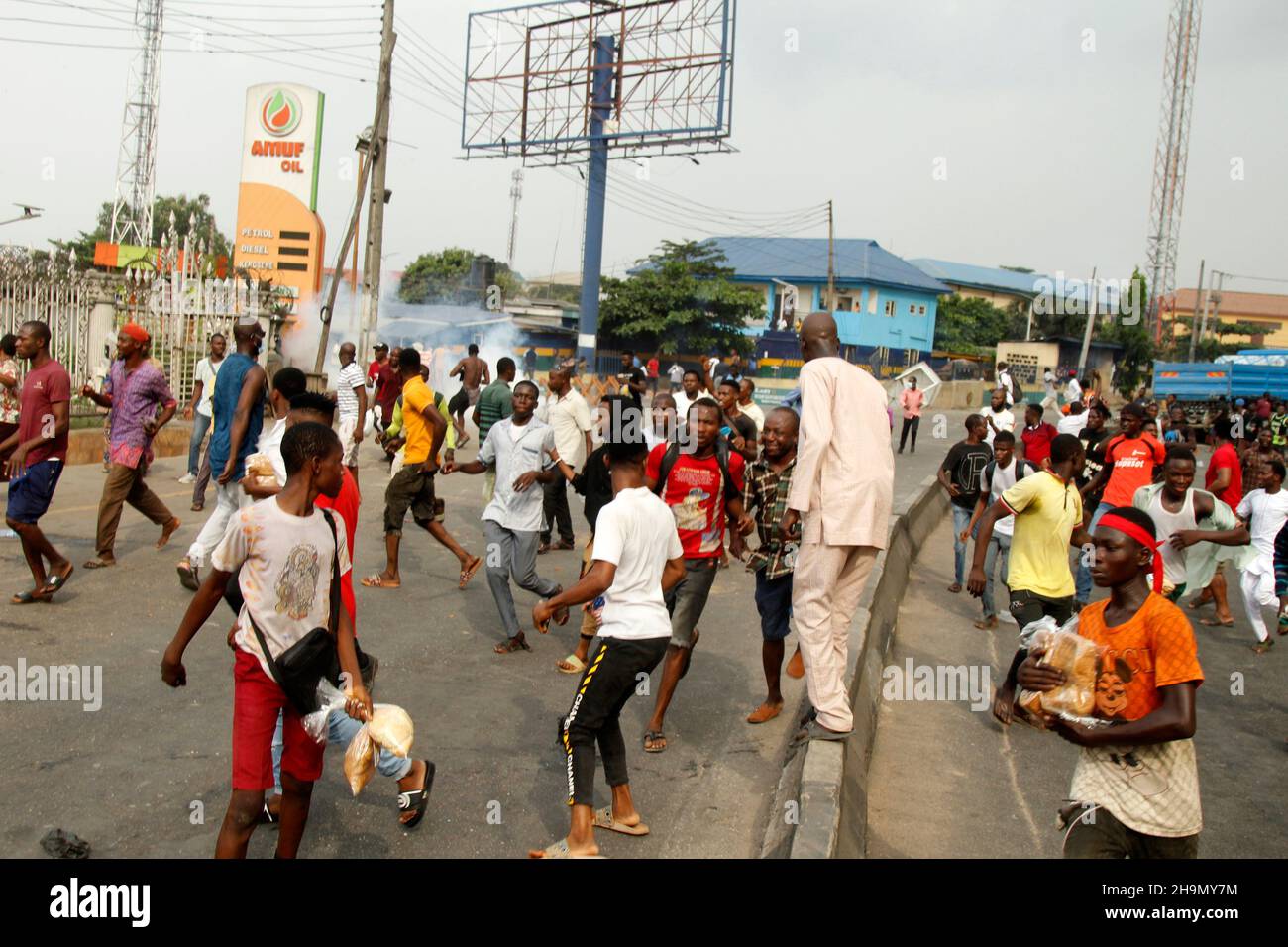 Lagos, Nigeria, 7th. Dezember 2021. Demonstranten fliehen vor Polizeitrengas am Gymnasium in Ojodu, Lagos, Nigeria, wo ein Lieferwagen, der angeblich von Verkehrsbeamten verfolgt wurde, einige Studenten tötete, die von der Schule zurückkehrten. Während der Augenzeuge sagte, dass mindestens 17 Schüler starben, bestätigte die Polizei am Dienstag, dass drei Tote, 12 Verletzte, bei dem Unfall starben. Foto von Adekunle Ajayi Stockfoto