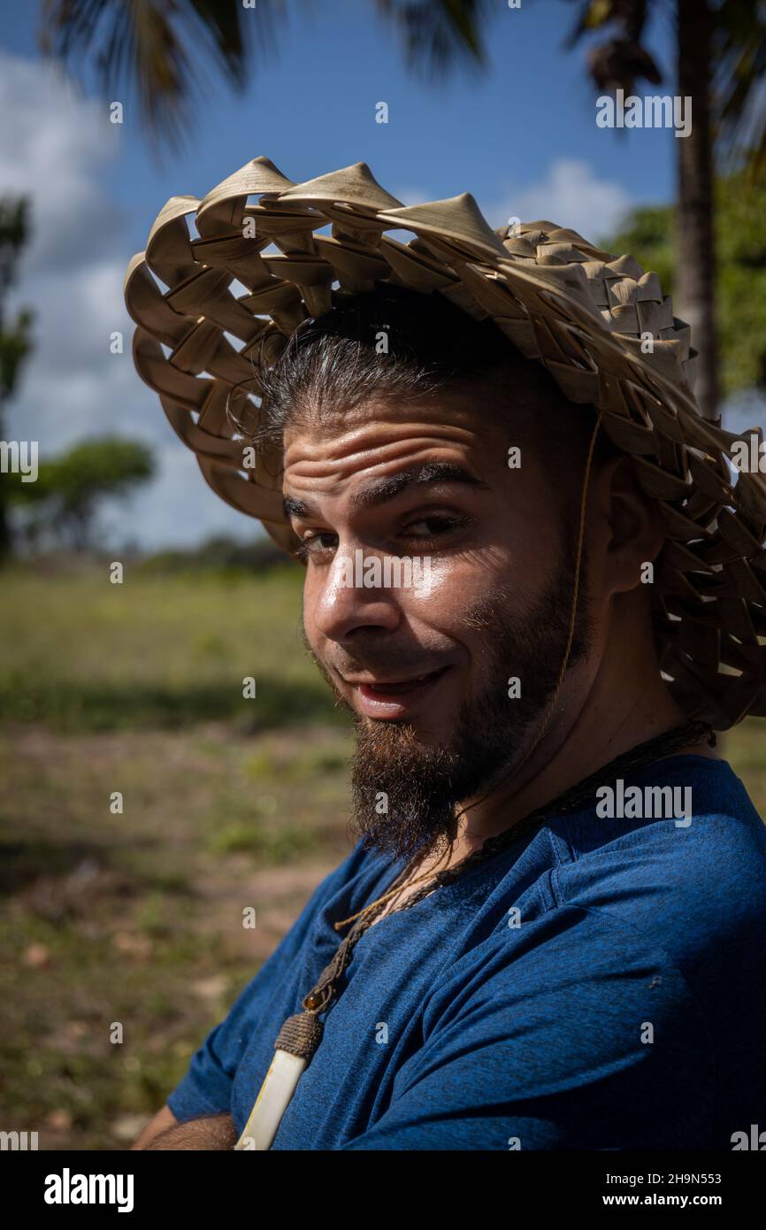 Mann von jungem Alter und Hipster-Look mit lustigen Ausdruck. Hut aus Palmblättern. Stockfoto