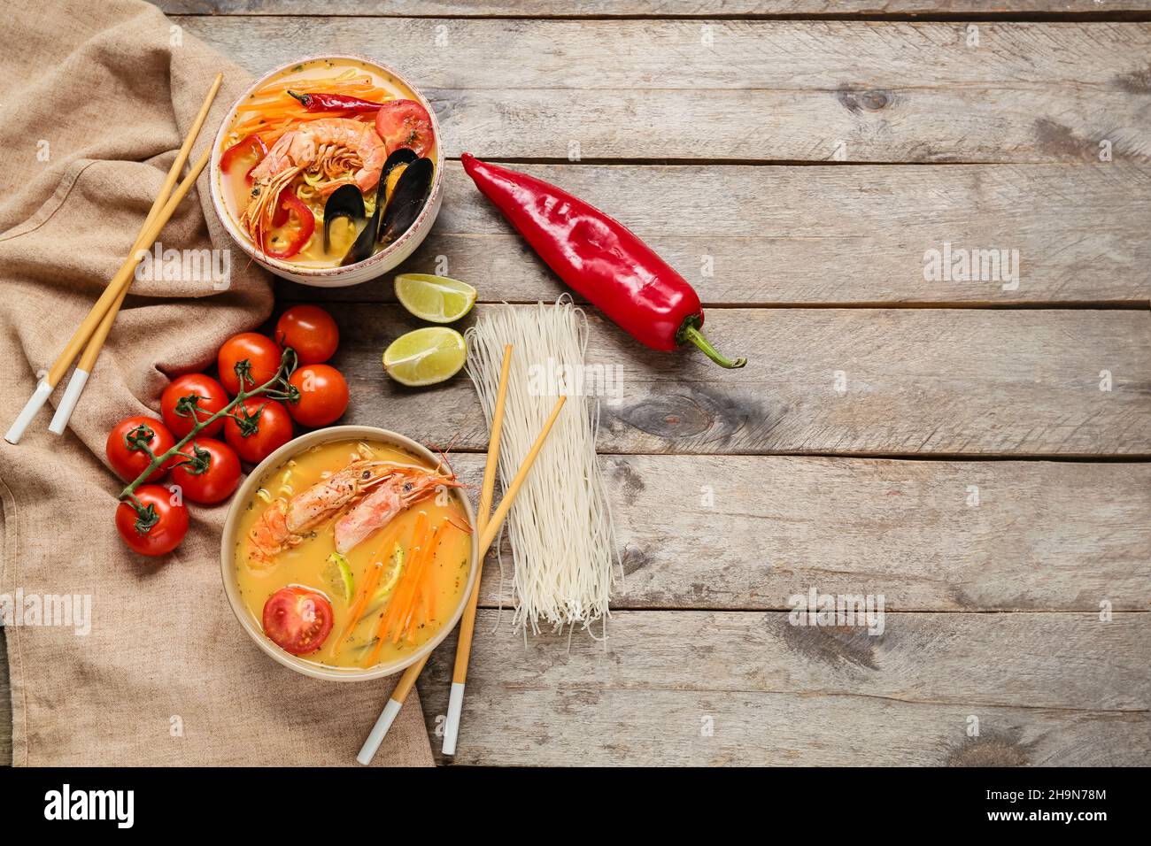 Schüsseln mit leckerer Thai-Suppe auf Holzhintergrund Stockfoto