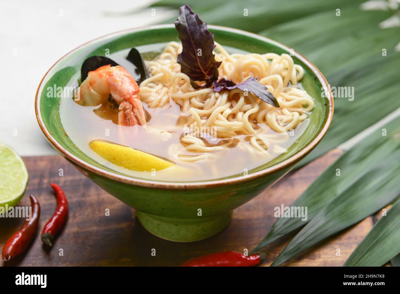 Schüssel mit würziger Thai-Suppe auf dem Tisch Stockfoto